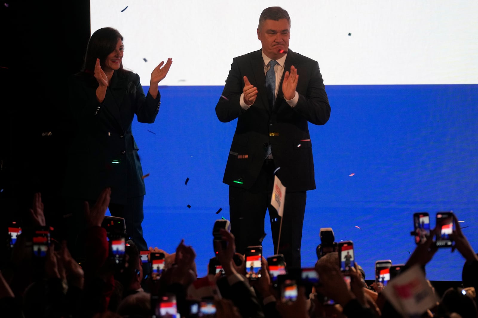 President incumbent Zoran Milanovic with his wife Sanja Music Milanovic greets supporters as the preliminary results grant him victory in a runoff vote for the Croatian presidential election in Zagreb, Croatia, Sunday, Jan. 12, 2025. The sign reads "Thank You". (AP Photo/Darko Bandic)