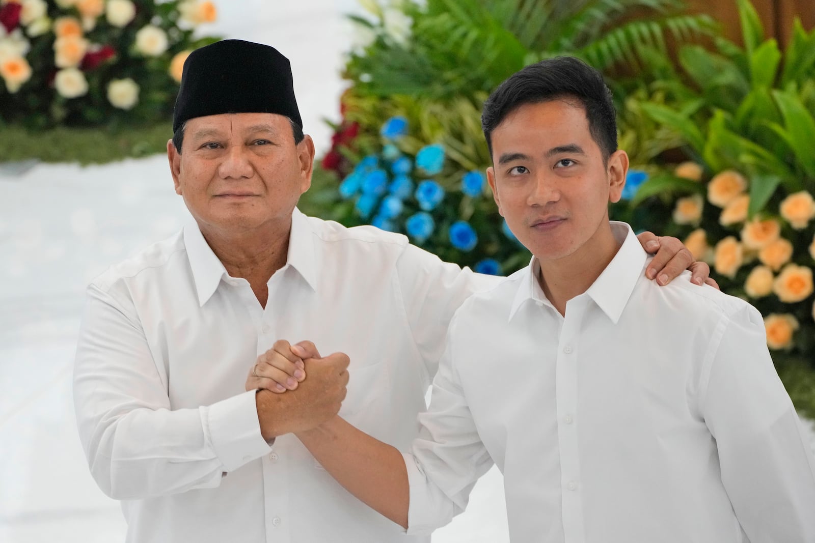 FILE - Indonesian Defense Minister and president-elect Prabowo Subianto, left, shakes hands with his running mate Gibran Rakabuming Raka, the eldest son of Indonesian President JokoWidodo, during their formal declaration as president and vice president-elect at the General Election Commission building in Jakarta, Indonesia, Wednesday, April 24, 2024. (AP Photo/Dita Alangkara, File)