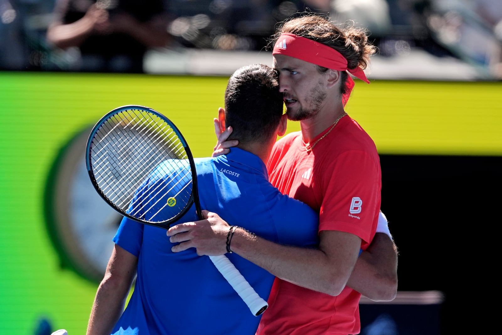 Alexander Zverev of Germany embraces Novak Djokovic of Serbia after Djokovic retired from their semifinal match at the Australian Open tennis championship in Melbourne, Australia, Friday, Jan. 24, 2025. (AP Photo/Ng Han Guan)