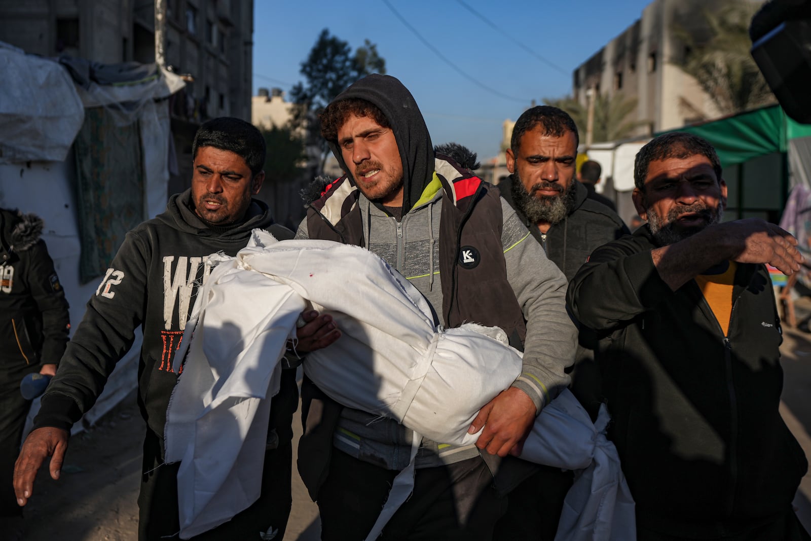 Palestinians carry the body of a relative killed in the Israeli bombardment of the Gaza Strip, at Al-Aqsa Hospital in Deir Al-Balah, Wednesday, Jan. 8, 2025. (AP Photo/Abdel Kareem Hana)