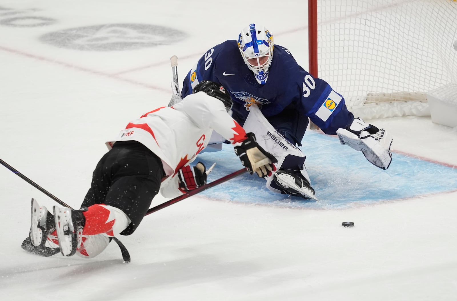 Canada forward Tanner Howe (23) falls after being tripped in front of Finland goaltender Petteri Rimpinen (30) during first period IIHF World Junior Hockey Championship tournament action, Thursday, Dec. 26, 2024, in Ottawa. (Adrian Wyld/The Canadian Press via AP)