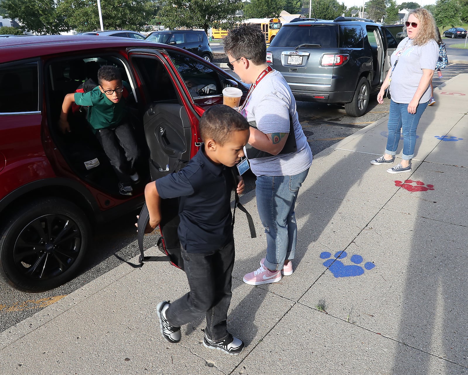 Staff at Lagonda Elementary help students get where they need to be as their dripped off on the first day of school Wednesday morning. BILL LACKEY/STAFF