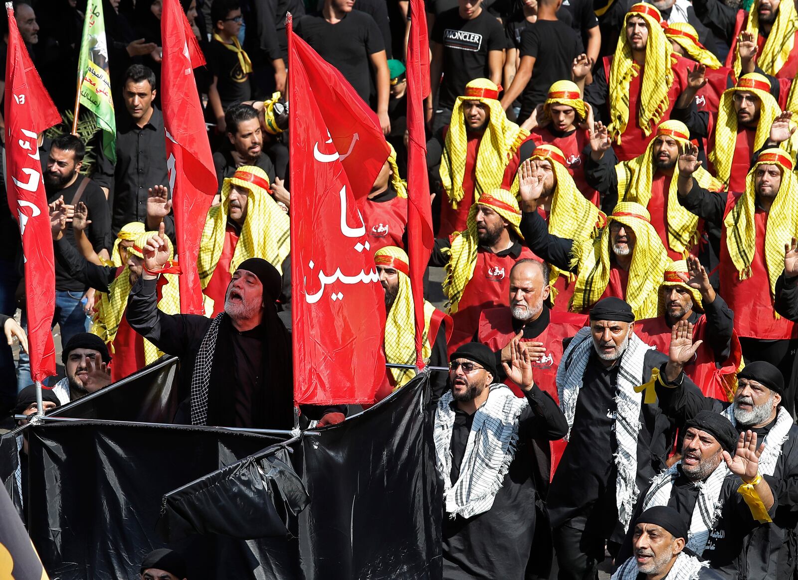 FILE - In this Sept. 10, 2019, file photo, Lebanese Shiite supporters of the Iranian-backed Hezbollah group raise their fists and chant slogans during Ashoura, the Shiite Muslim commemoration marking the death of Hussein, the grandson of the Prophet Muhammad, in present-day Iraq in the seventh century, Tuesday, Sept. 10, 2019, in Beirut, Lebanon. Shiites mark Ashoura, the 10th day of the month of Muharram, to commemorate the Battle of Karbala when Imam Hussein, a grandson of Prophet Muhammad, was killed. (AP Photo/Hussein Malla, File)