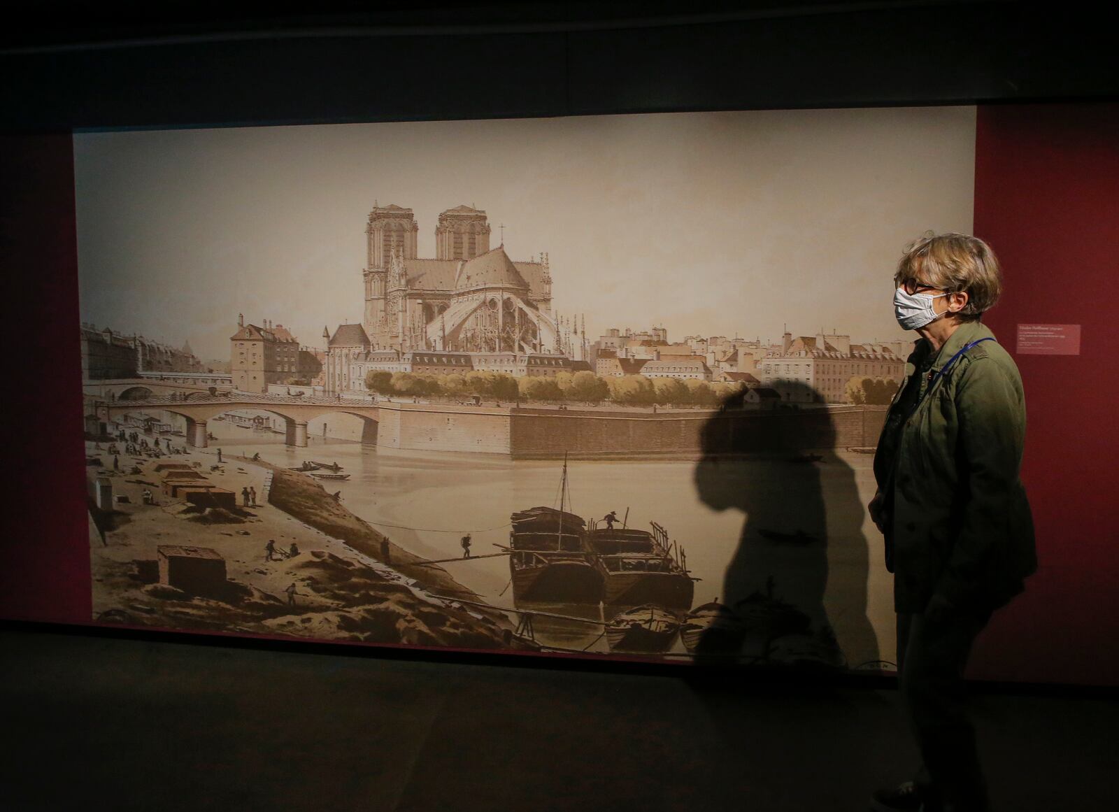 A woman wearing a protective face masks as precaution against the conoravirus visits archaeological crypt underneath the parvis of Notre-Dame cathedral which reopens today in in Paris, Wednesday, Sept. 9, 2020. The archaeological crypt was shut down after the cathedral caught fire in April 2019, and it returns with a exhibition called Notre-Dame de Paris from Victor Hugo to Eugene Viollet-le-Duc . (AP Photo/Michel Euler)