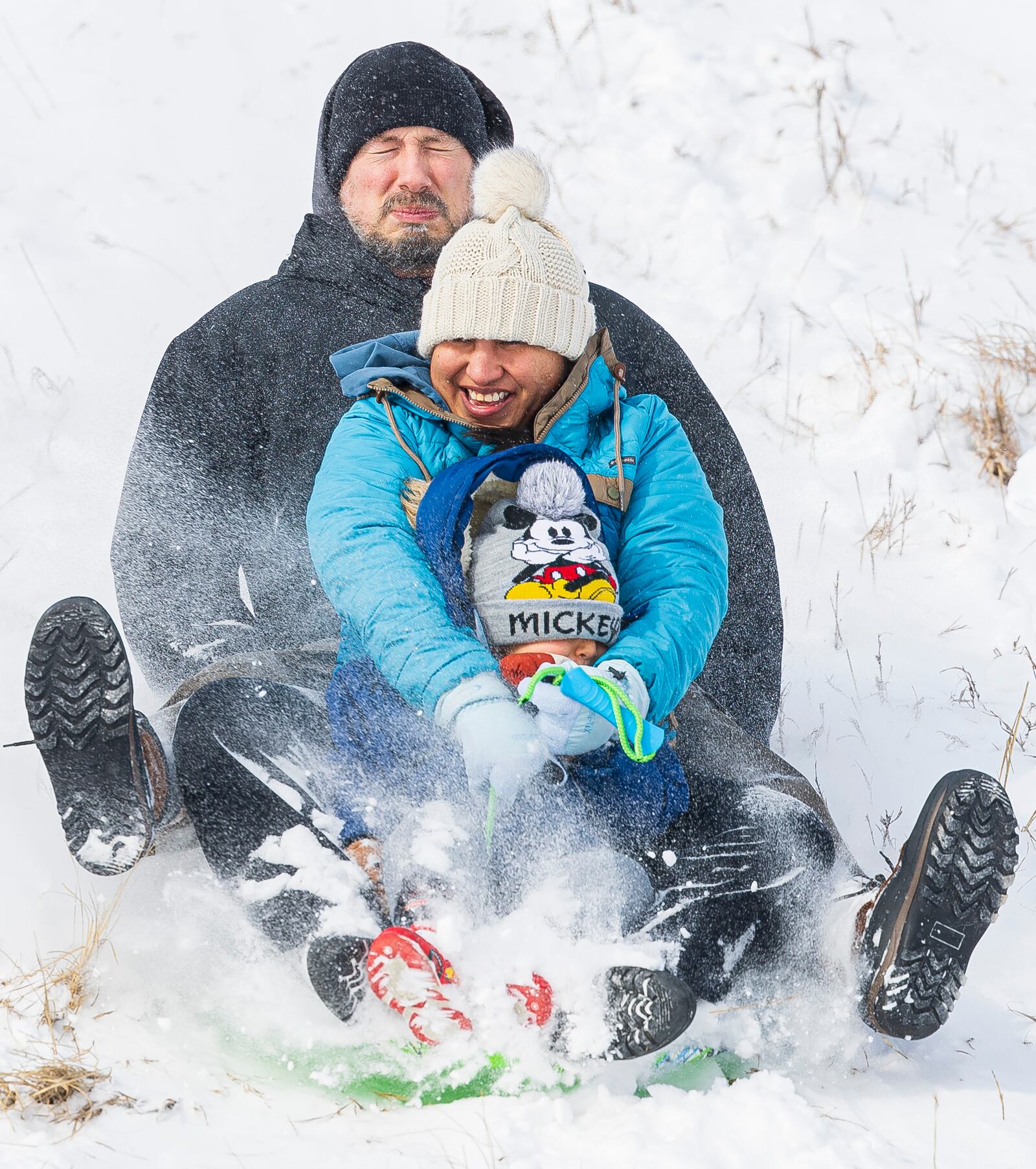 Rodney Meester, top, tries to steer his wife Marysol, and son Orlando, 4, down the Holmes Lake hill as a winter storm hits Lincoln, Neb., Wednesday, Feb. 12, 2025. (Kenneth Ferriera/Lincoln Journal Star via AP)