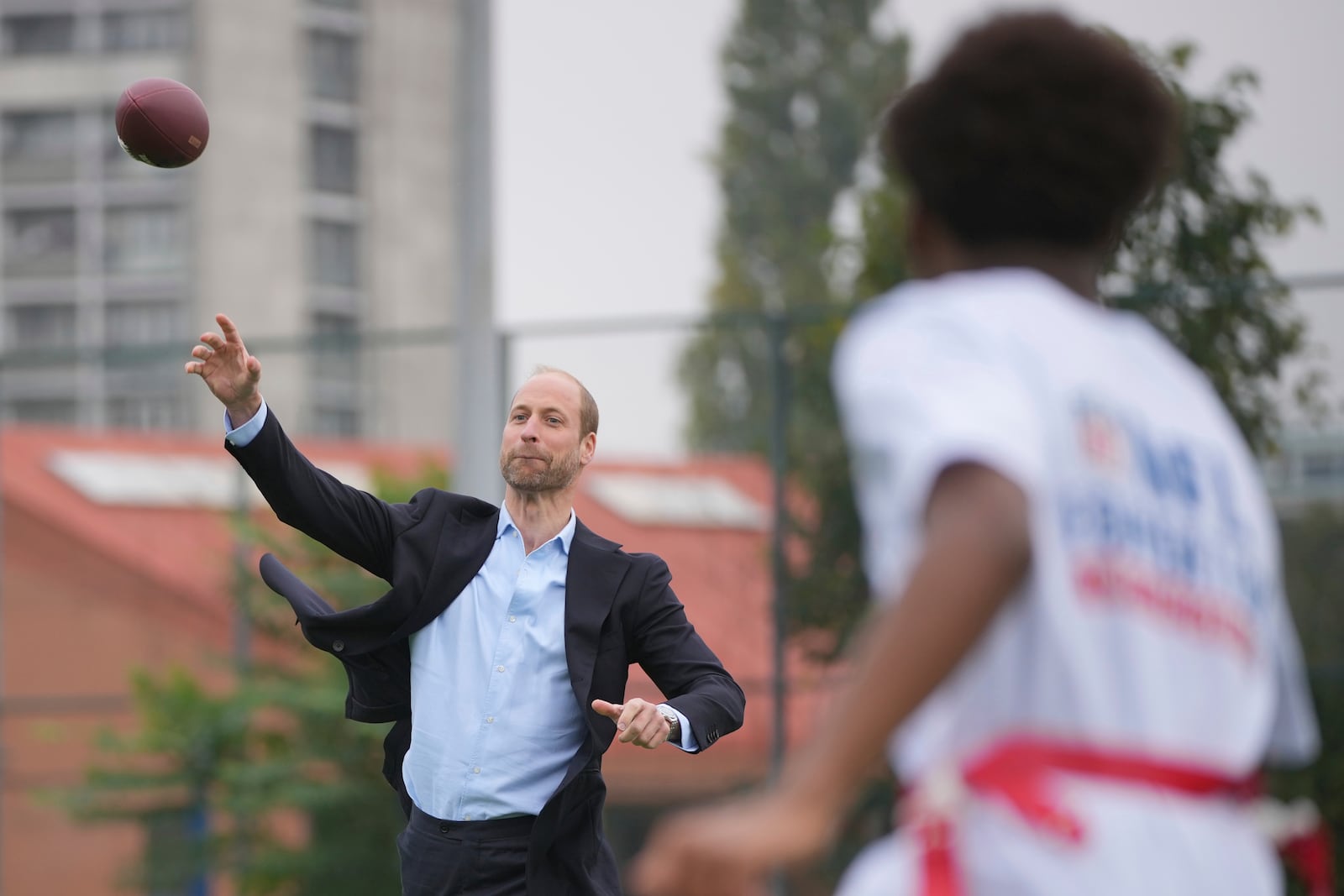 Britain's Prince William throws a football as he attends a NFL Foundation NFL Flag event, an inclusive and fast paced American Football format, in London, Tuesday, Oct. 15, 2024. (AP Photo/Kin Cheung, Pool)