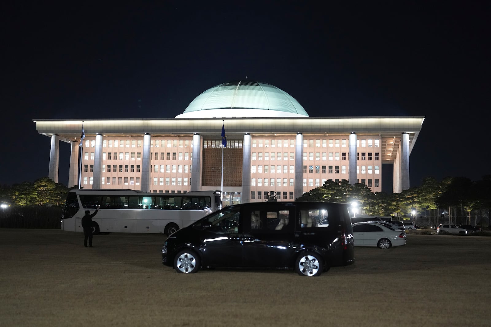 Vehicles are parked on the lawn of the National Assembly to prevent helicopters from landing due to concerns of any possible additional acts following the President's short-lived martial law declaration at the National Assembly in Seoul, South Korea, Friday, Dec. 6, 2024. (AP Photo/Lee Jin-man)