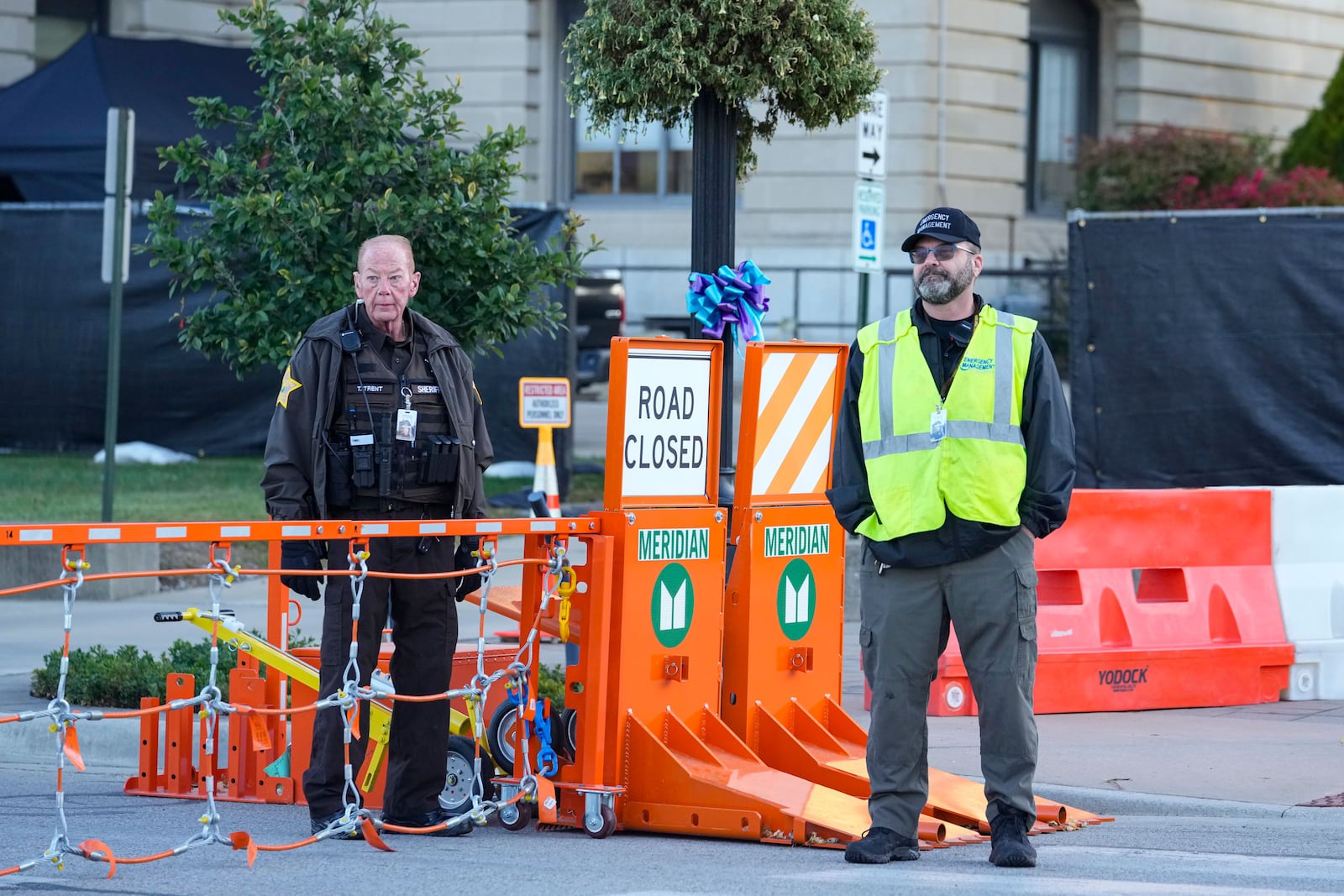 Security stands by a gate outside the Carroll County Courthouse where the trial of Richard Allen, accused of the slayings of two teenage girls in 2017, is set to begin in Delphi, Ind., Friday, Oct. 18, 2024. (AP Photo/Michael Conroy)