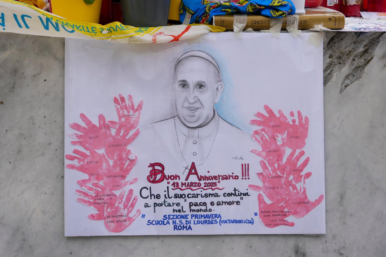 A poster depicting Pope Francis reading "happy anniversary" is seen in front of the Agostino Gemelli Polyclinic, in Rome, Thursday, March 13, 2025, where the Pontiff is hospitalized since Friday, Feb. 14. (AP Photo/Andrew Medichini)