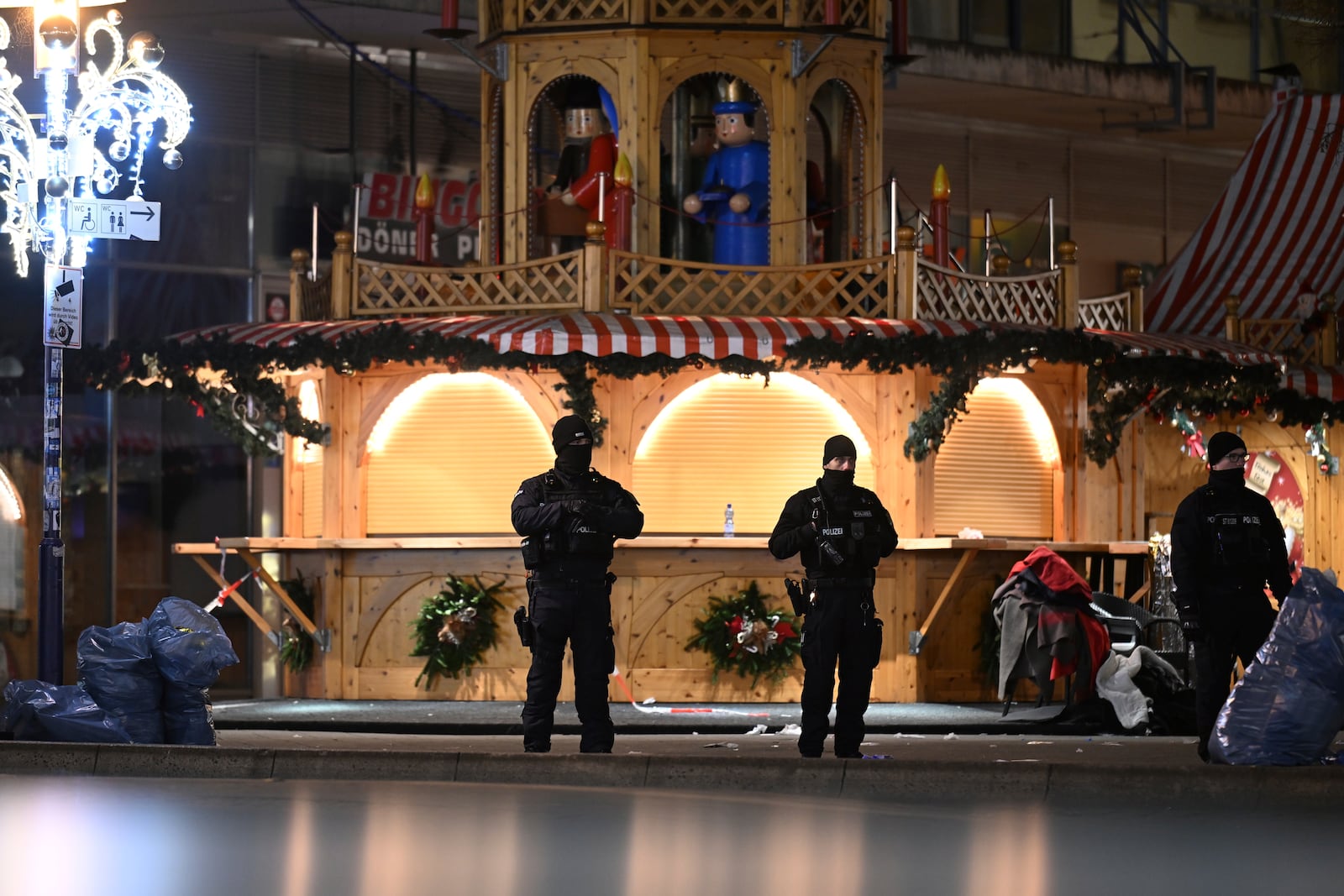 Police stand at a Christmas market in Magdeburg, Germany, early Saturday, Dec. 21, 2024, after a driver plowed into a group of people at the market late Friday. (Hendrik Schmidt/dpa via AP)