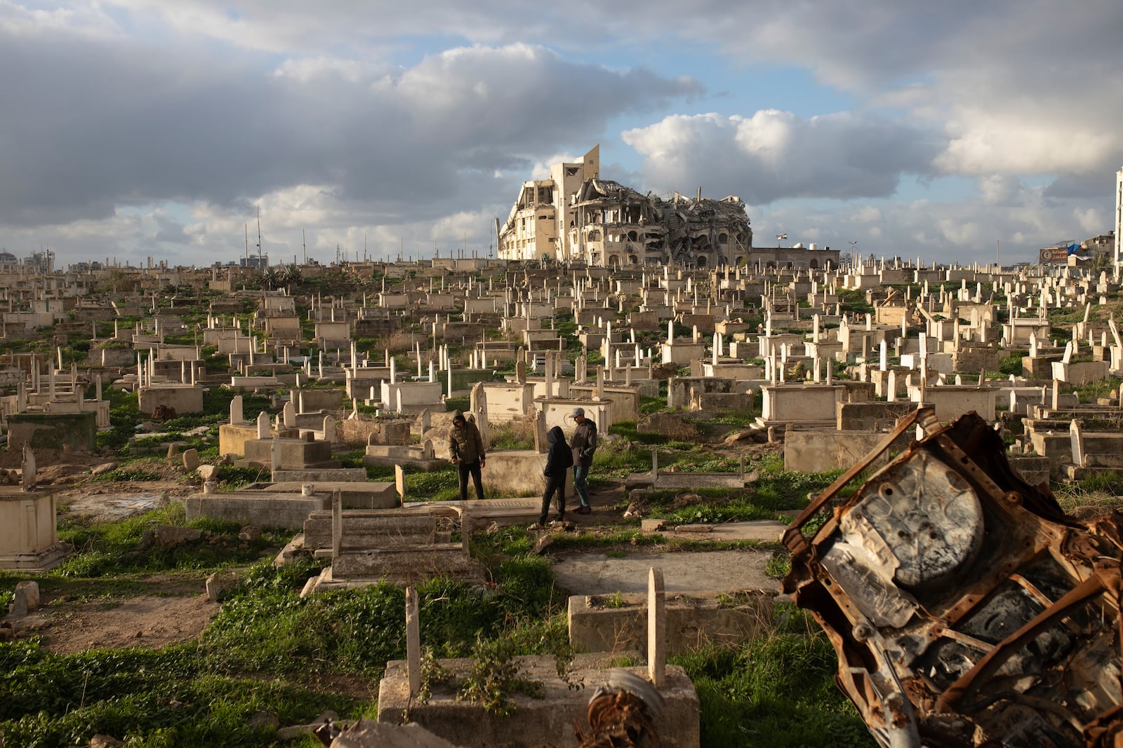 Palestinians visit the grave of a relative at the cemetery in Gaza City Thursday, Feb. 6, 2025, after collecting donated food. (AP Photo/Jehad Alshrafi)