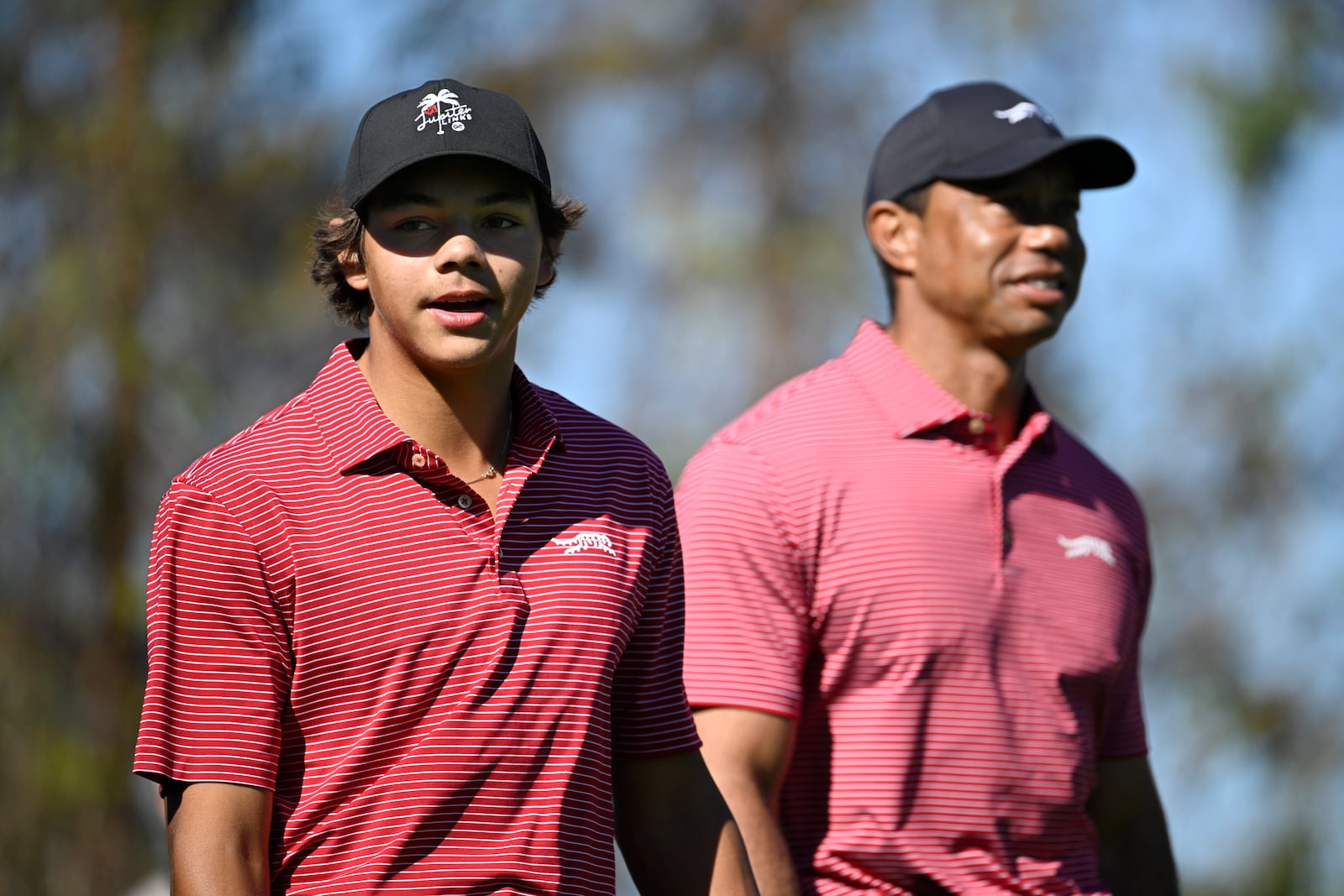 Charlie Woods, left, walks on the fourth fairway after hitting a hole-in-on as his father Tiger Woods follows during the final round of the PNC Championship golf tournament, Sunday, Dec. 22, 2024, in Orlando, Fla. (AP Photo/Phelan M. Ebenhack)