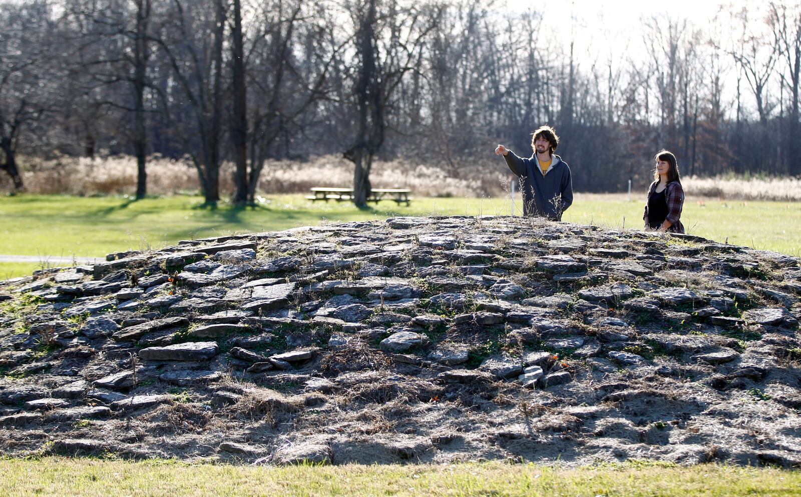 Visitors Matt Berger, left, and Kristen Wickert observe a mound at Fort Ancient that is astronomically aligned with the Winter Solstice.   Fort Ancient Earthworks outside Lebanon are one stop on the Ancient Ohio Trail, a system of Native American heritage sites a retired UC professor is turning into a global tourist attraction.John Hancock, a retired architecture professor at UC, is also helping put together the application for Fort Ancient, managed by the Dayton Society of Natural History, and other Ohio sites to be designated as a World Heritage Site. But the Ancient Ohio Trail is a separate initiative designed to draw tourists to Ohio.  TY GREENLEES / STAFF