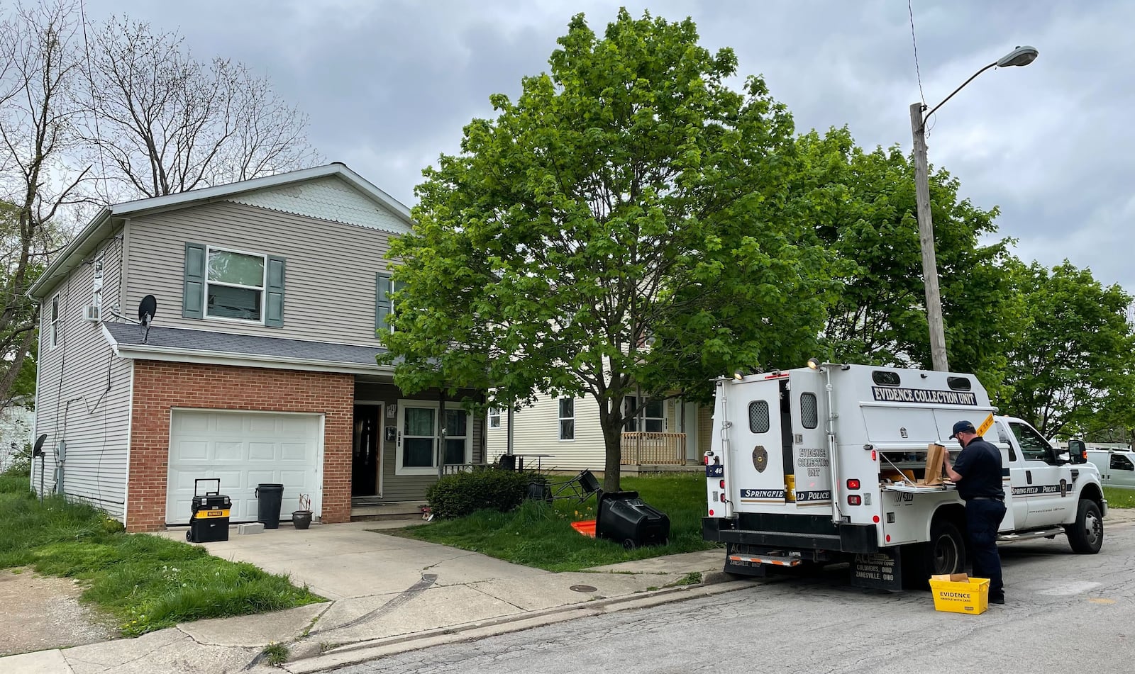 A Springfield Police Division evidence collection unit is in front of a house where a raid was underway Thursday, May 5, 2022, in the 400 block of Vine Street. BILL LACKEY/STAFF