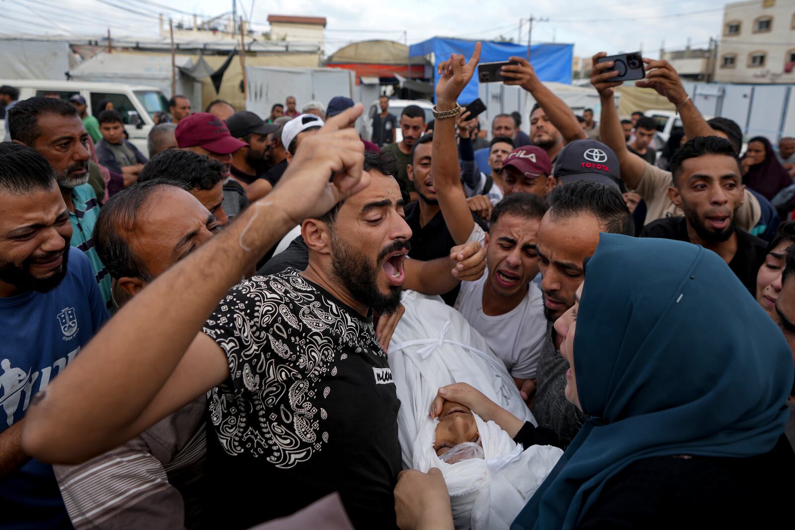 Palestinians mourn a relative killed in the Israeli bombardment of the Gaza Strip at a hospital in Deir al-Balah, Tuesday, Oct. 8, 2024. (AP Photo/Abdel Kareem Hana)