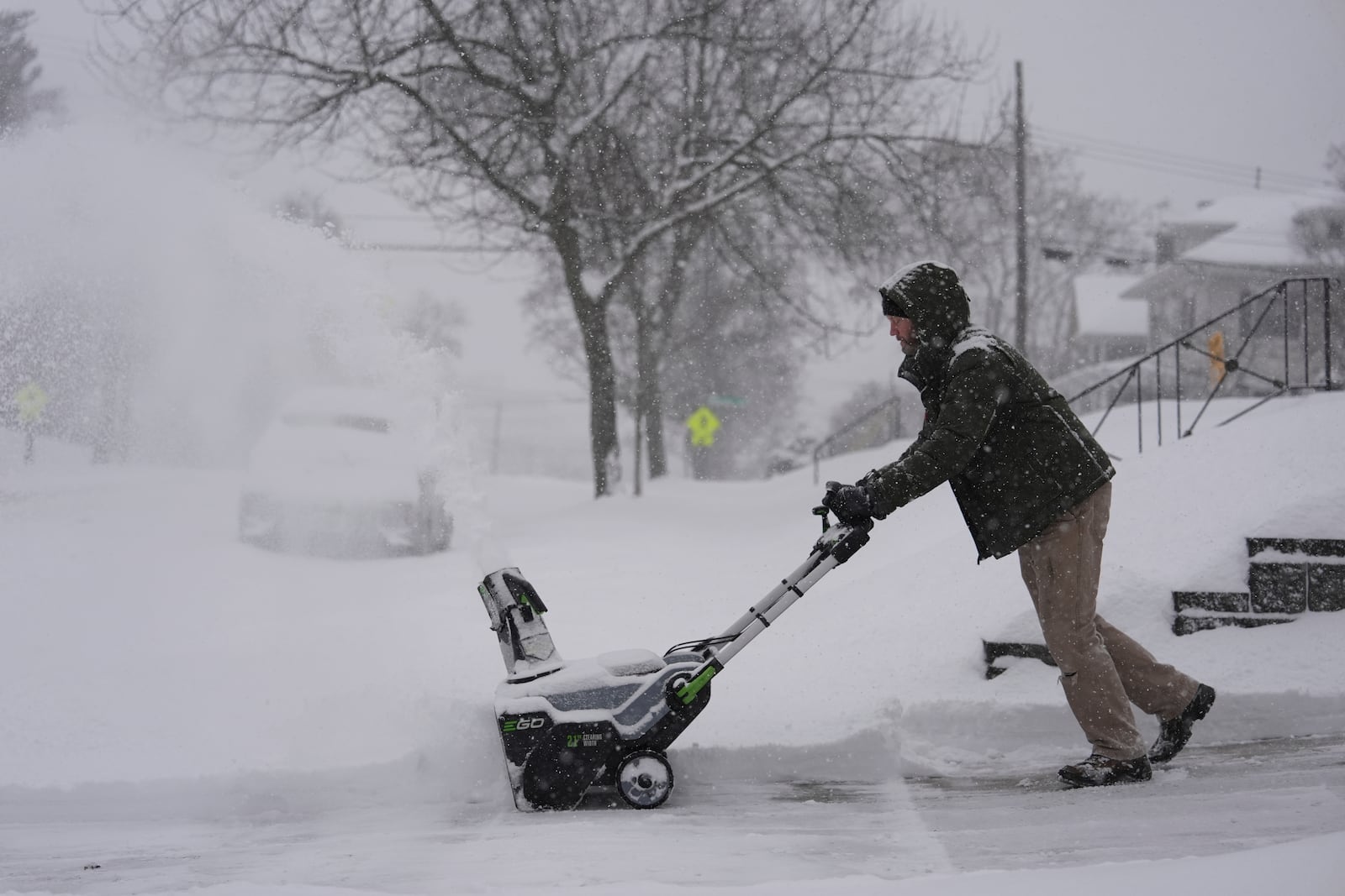 Carl Rich uses a snowblower to clear his driveway during a winter storm, Monday, Jan. 6, 2025, in Cincinnati. (AP Photo/Joshua A. Bickel)