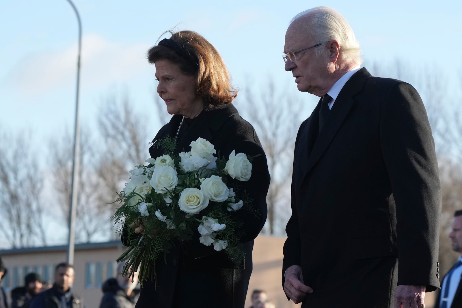 Sweden's King Carl XVI Gustaf and Queen Silvia arrive to place flowers at a memorial near the scene of a shooting on the outskirts of Orebro, Sweden, Wednesday, Feb. 5, 2025. (AP Photo/Sergei Grits)