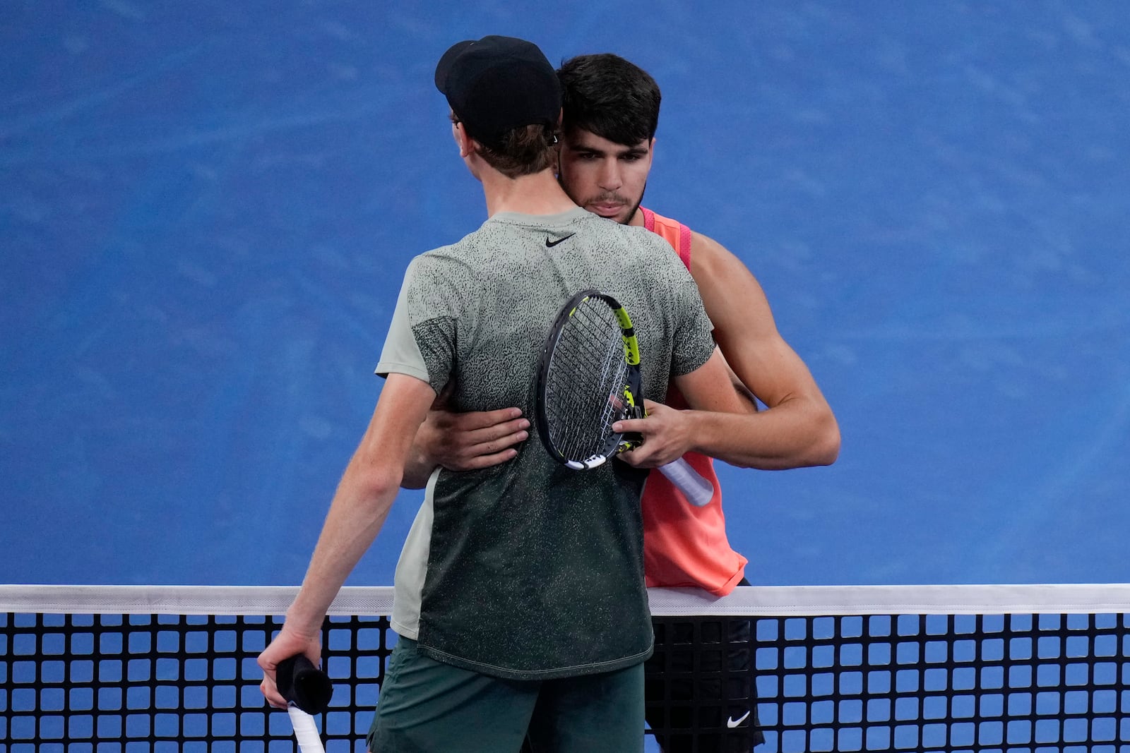 Carlos Alcaraz, right, of Spain approaches the net after winning against Jannik Sinner of Italy during their men's singles finals match of the China Open tennis tournament, at the National Tennis Center in Beijing, Wednesday, Oct. 2, 2024. (AP Photo/Andy Wong)