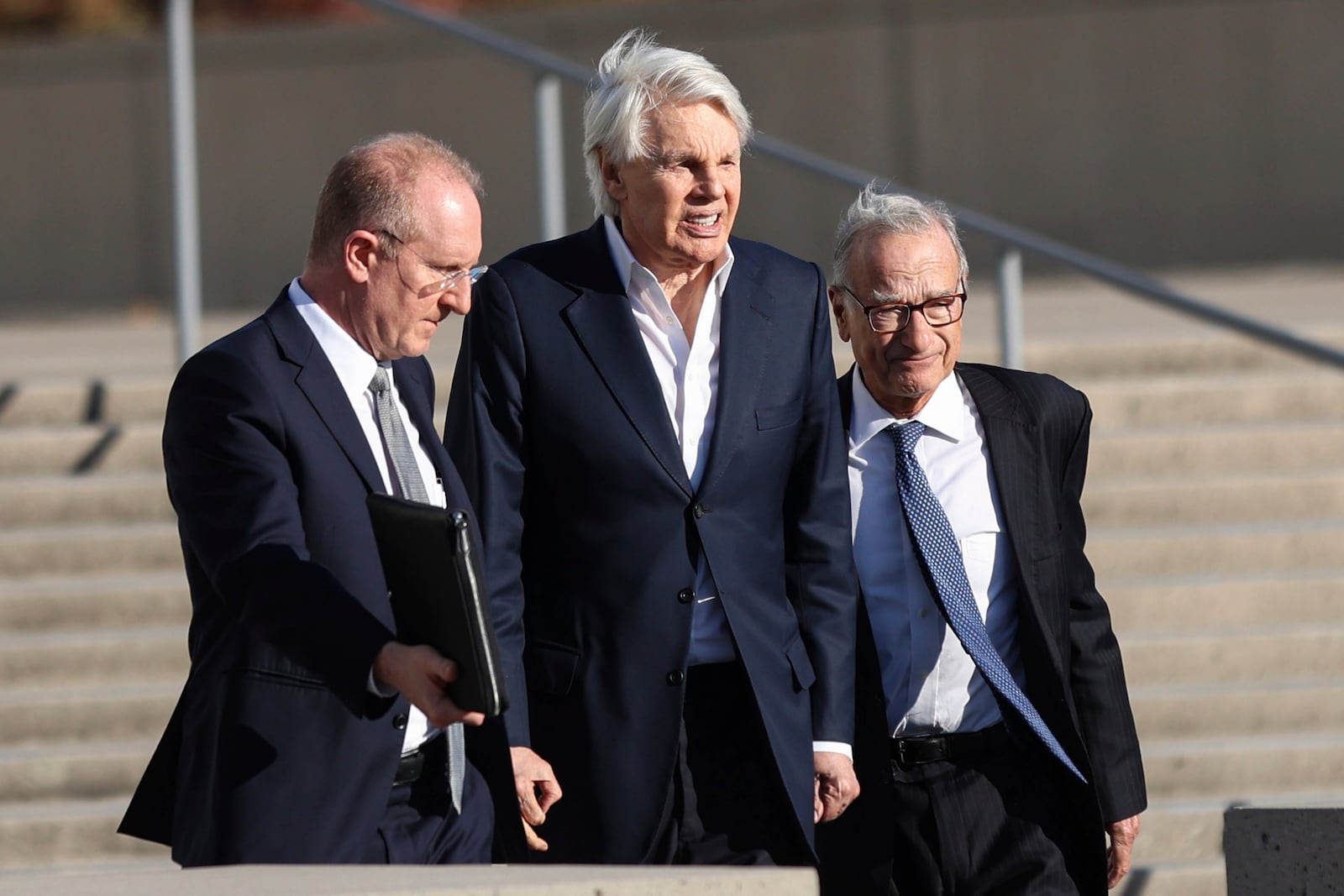 Michael Jeffries, center, former CEO of Abercrombie & Fitch, exits the federal courthouse after his arraignment on sex trafficking and interstate prostitution charges, Friday, Oct. 25, 2024, in Central Islip, N.Y. (AP Photo/Heather Khalifa)