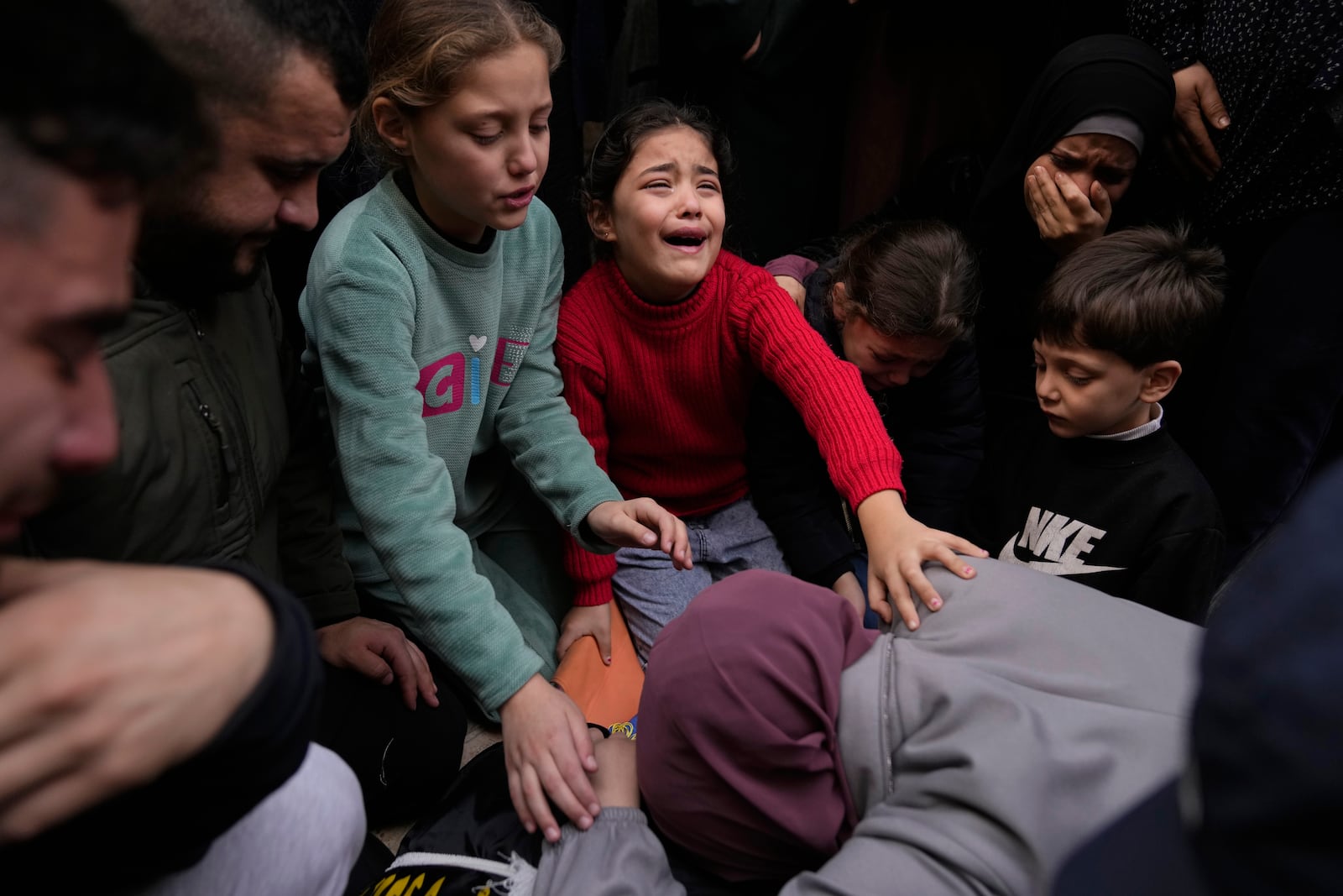 From center right, Younes 6, Isra' 10, Ala, 7 and Asma' 12, in green, cry while taking the last look at the body of their father Ahmad Ararawi, 37, wrapped with Islamic Jihad flag, during the funeral of six Palestinians who were killed during an Israeli airstrike on Wednesday, in the West Bank refugee camp of Jenin Thursday, Jan. 16, 2025. (AP Photo/Nasser Nasser)