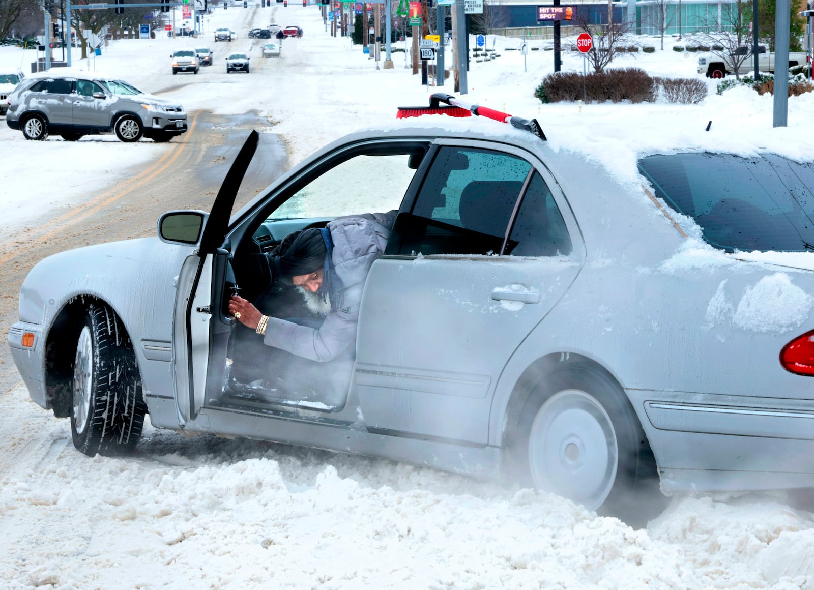 St. Ann resident Troupe El checks for traction on Monday, Jan. 6, 2025, after getting his vehicle stuck trying to enter St. Charles Rock Road from the Crossings at Northwest in St. Ann, Mo. (Christian Gooden/St. Louis Post-Dispatch via AP)