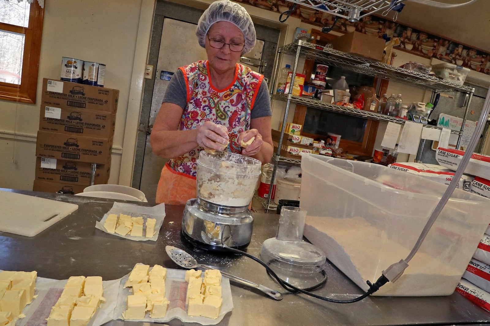 Sue Littlejohn adds butter to the flour mixture to be used for the pie crusts at Stevens Family Bakery & Orchard. BILL LACKEY/STAFF