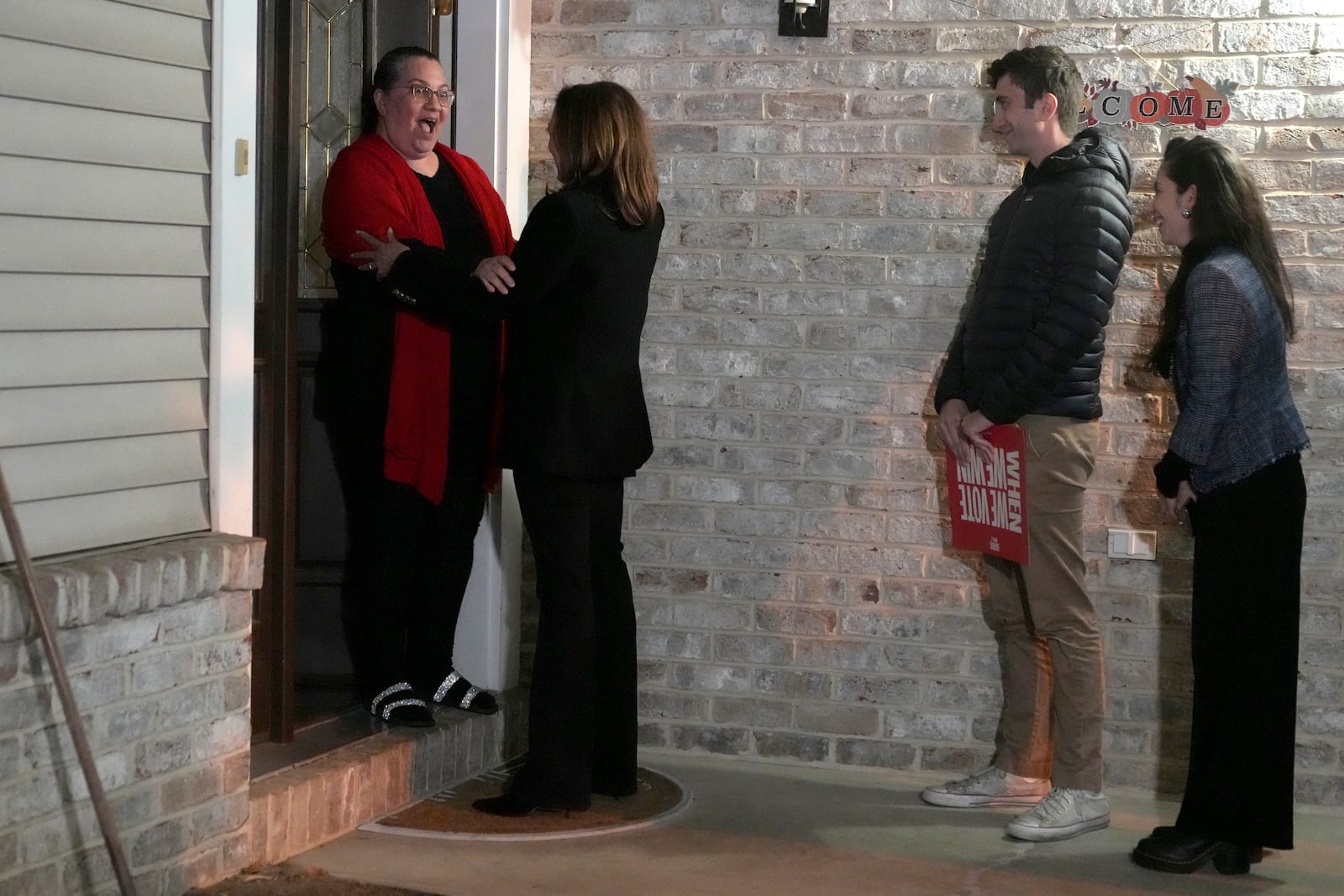 Democratic presidential nominee Vice President Kamala Harris, second left, and two campaign volunteers, right, speak to a voter as Harris knocks on doors during a campaign stop in Reading, Pa., Monday, Nov. 4, 2024. (AP Photo/Jacquelyn Martin)