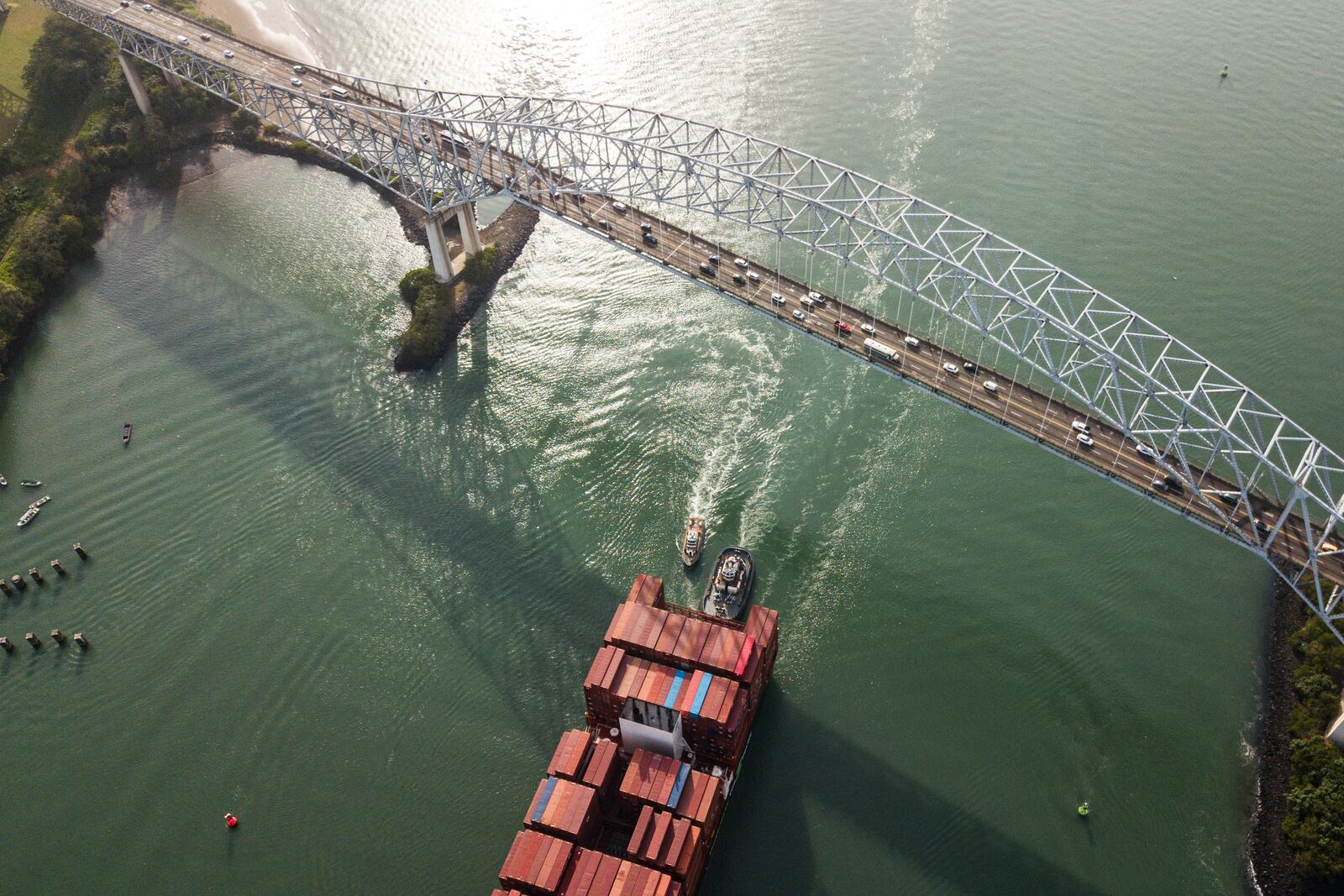 A cargo ship sails under Las Americas bridge through the Panama Canal, in Panama City, Saturday, Feb. 1, 2025. (AP Photo/Matias Delacroix)