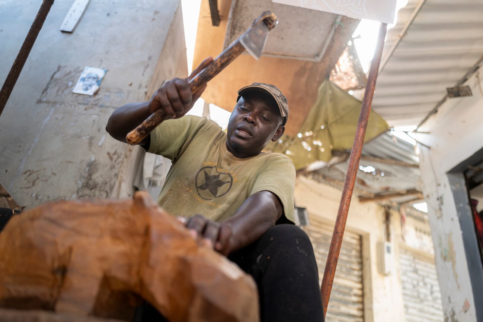 Woodcarver Papis Kanté sculpts a wooden hippopotamus to be exhibited in the "Rebondir" exhibition as part of the Dakar 2024 Biennial Off in Dakar, Senegal, Thursday, Nov. 28, 2024. (AP Photo/Sylvain Cherkaoui)