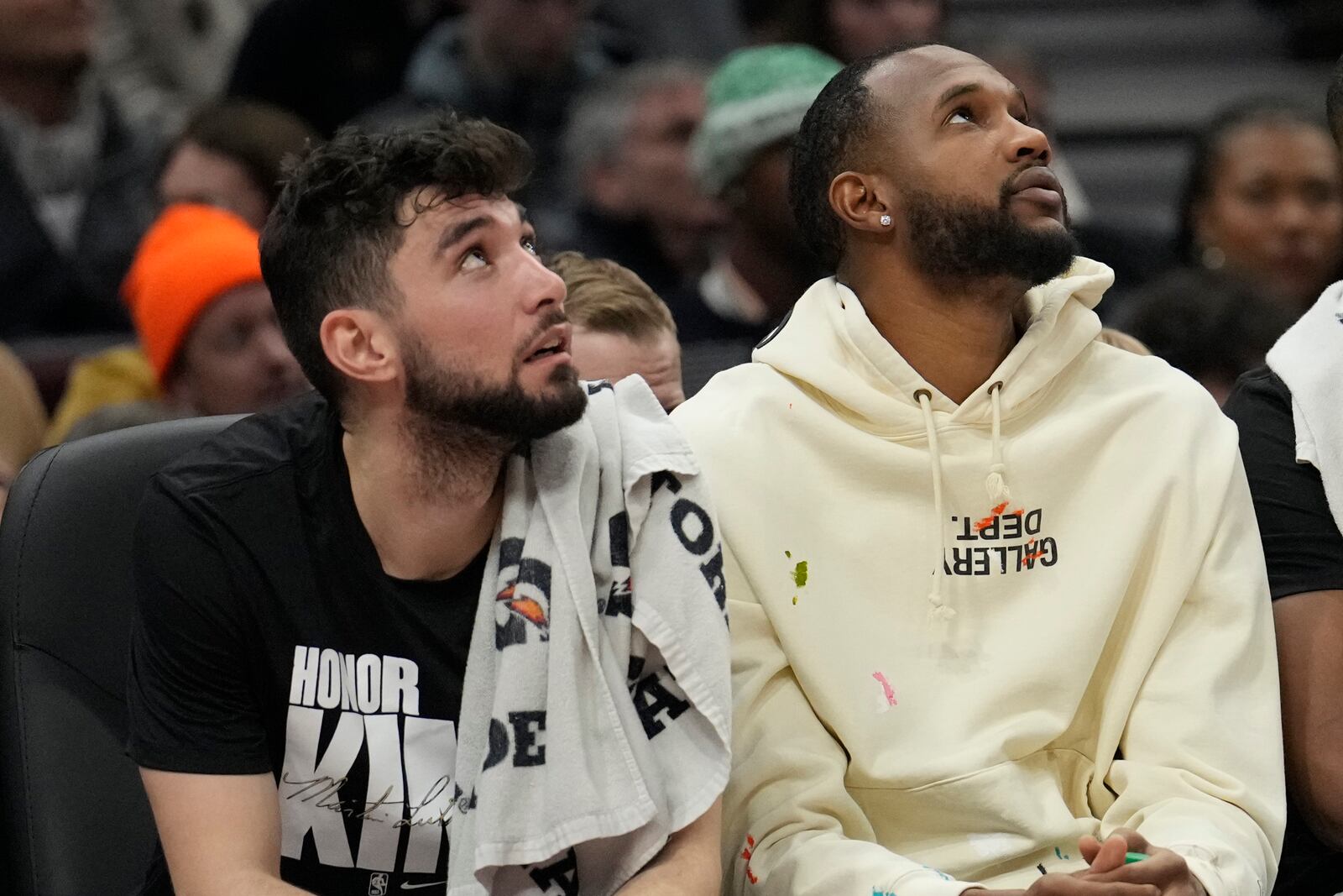 Cleveland Cavaliers guard Ty Jerome, left, and injured forward Evan Mobley, right, look up at the scoreboard in the first half of an NBA basketball game against the Phoenix Suns, Monday, Jan. 20, 2025, in Cleveland. (AP Photo/Sue Ogrocki)