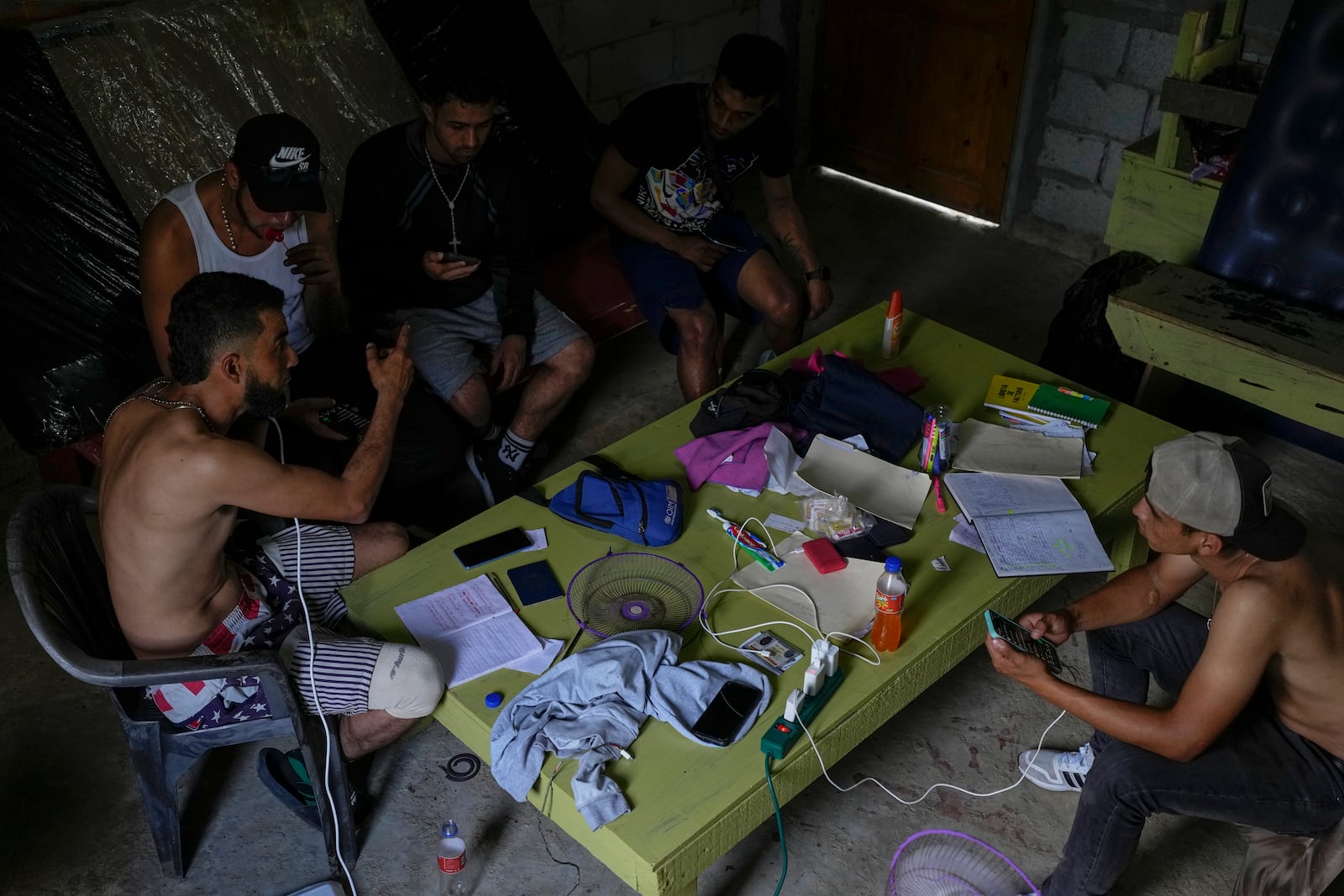 Venezuelan migrants talk to a local, left, about boat fees to Colombia, in Puerto Carti, on Panama's Caribbean coast, Sunday, Feb. 23, 2025, on their way back home from southern Mexico where they gave up hopes of reaching the U.S. amid President Trump's crackdown on migration. (AP Photo/Matias Delacroix)