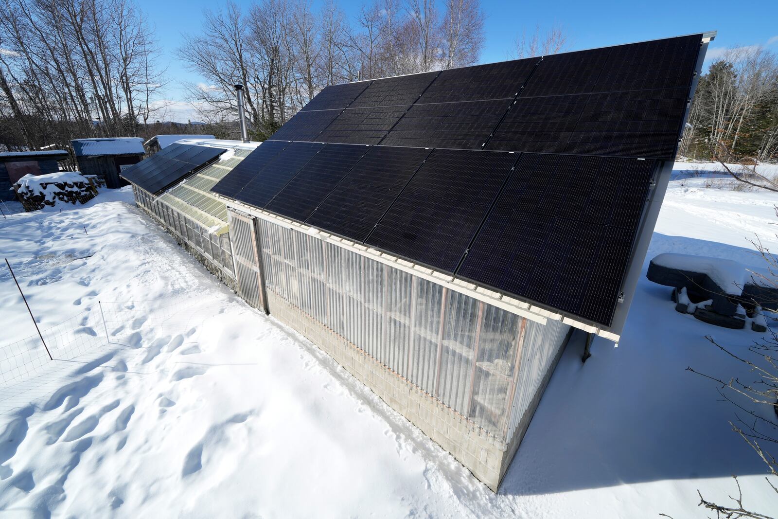 Solar panels on a workshop roof catch the sunlight at Intervale Farm, Monday, Feb. 10, 2025, in Cherryfield, Maine. (AP Photo/Robert F. Bukaty)