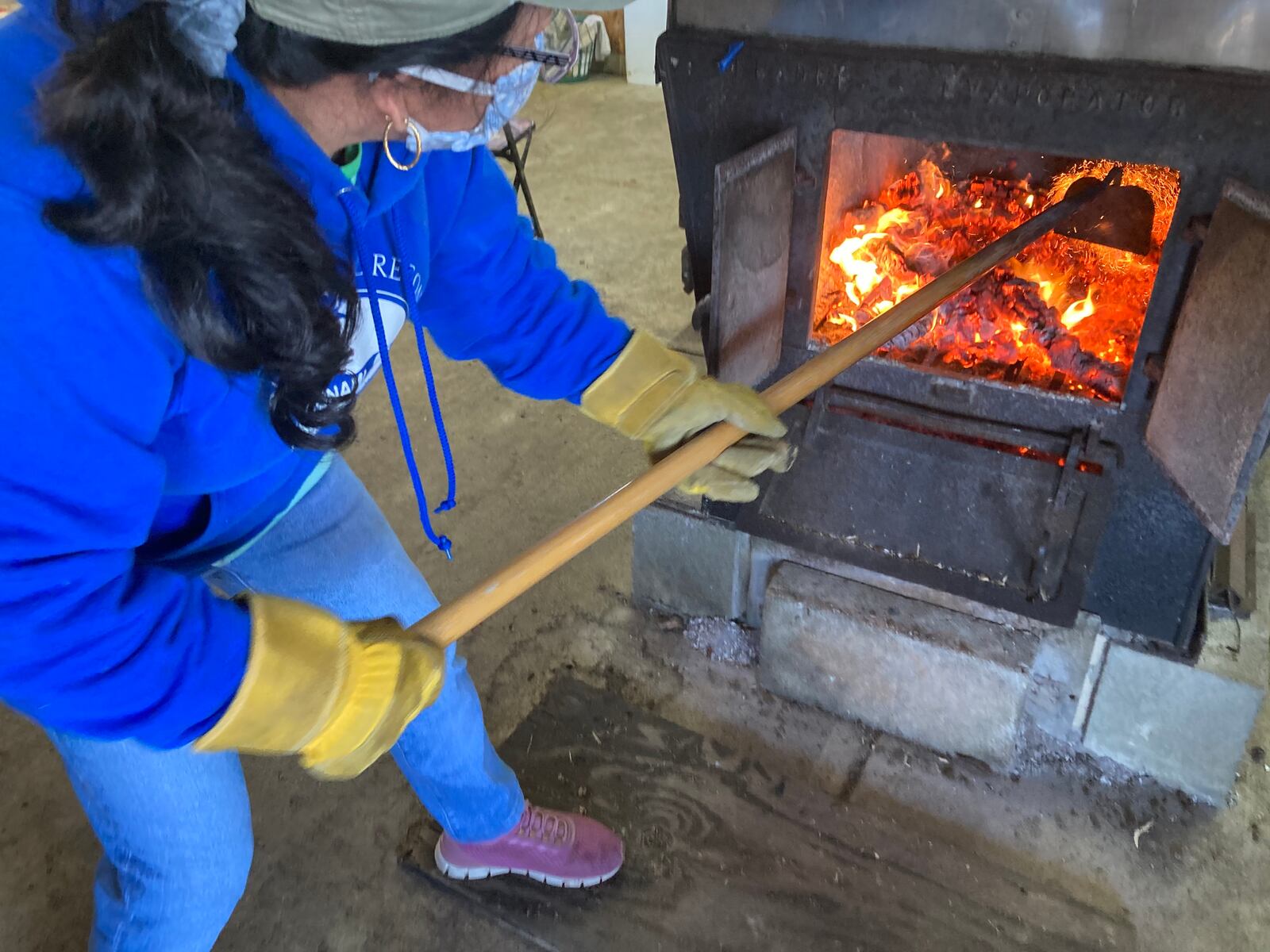 Lourdes Westbrook tends the fire in Ben Hamilton's sap cooker. TOM STAFFORD