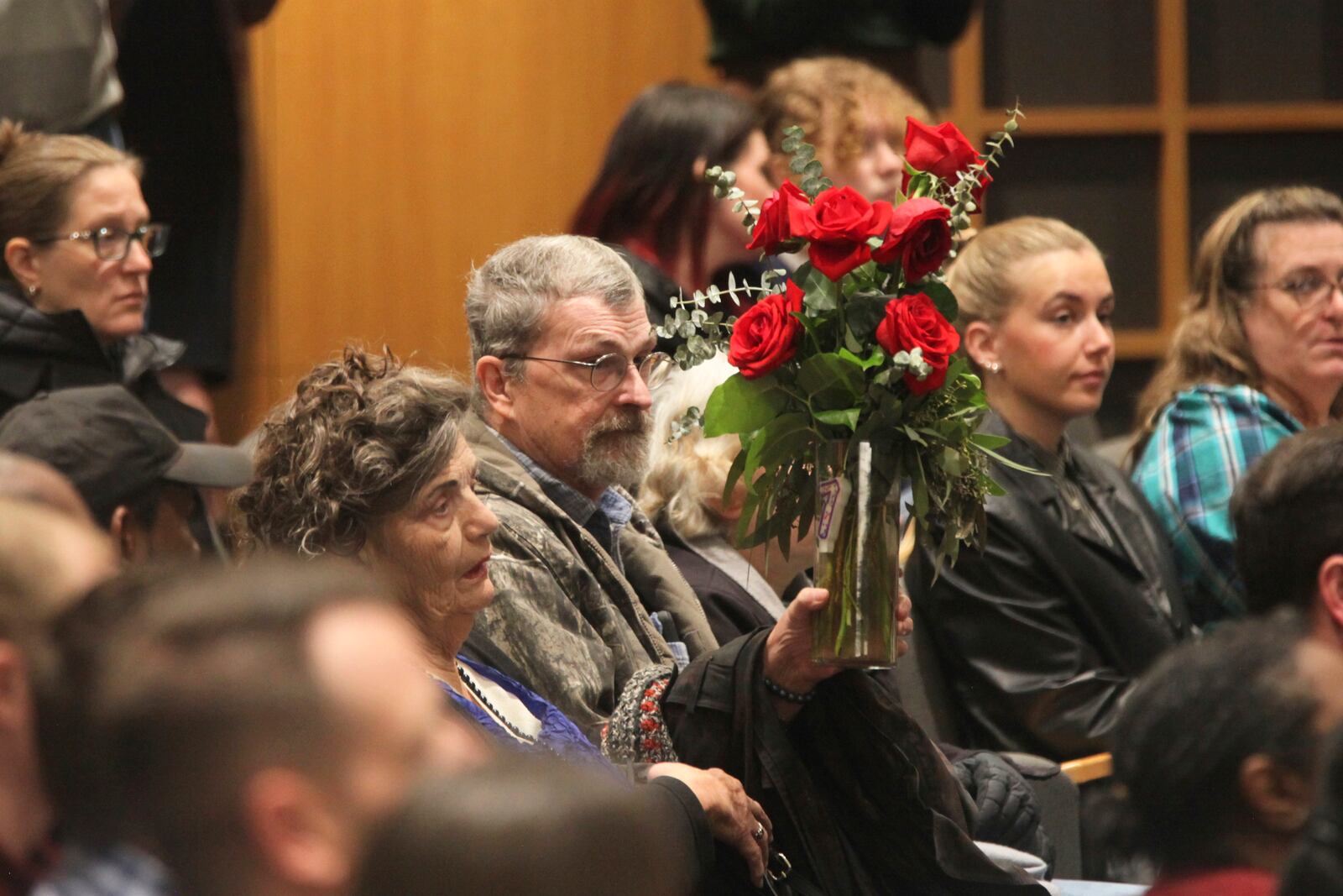 Carla Lee, a retired Wichita State University nursing professor, holds up a vase of red roses to show her support for the families of victims of a deadly collision between a passenger airliner and an Army helicopter that occurred the day prior, Thursday, Jan. 30, 2025, during a prayer vigil in Wichita, Kan., where the airline passenger flight originated. (AP Photo/John Hanna)