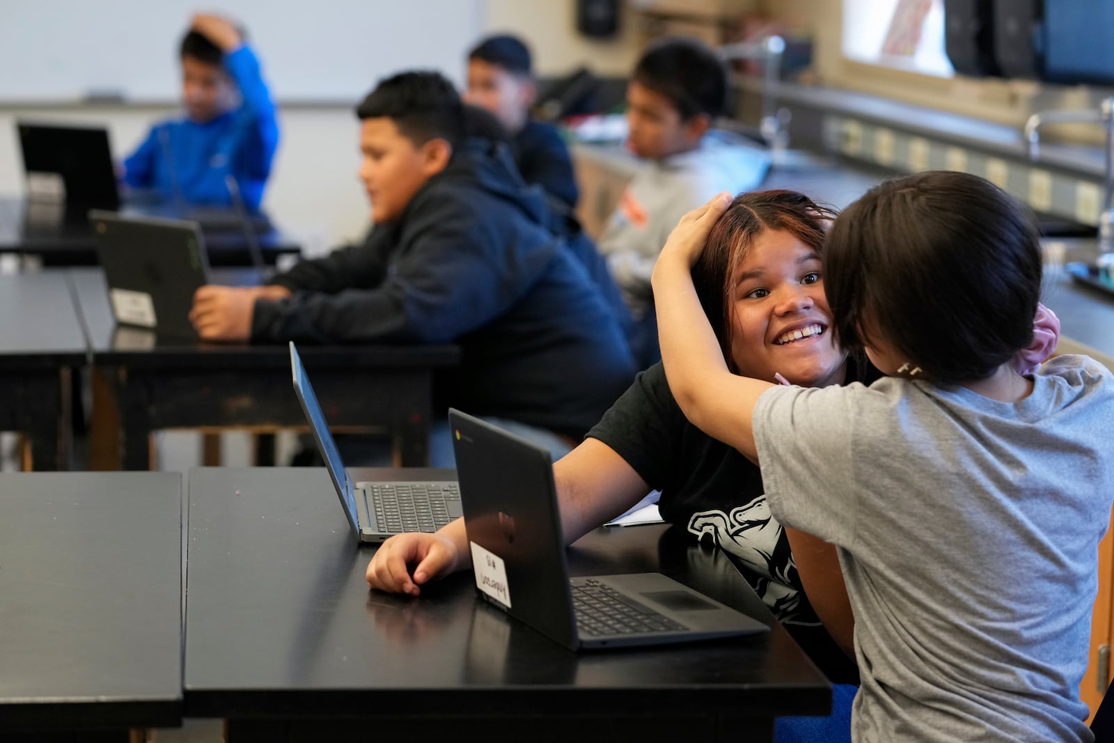 Alisson Ramírez, second from right, plays with a classmate during science class Wednesday, Aug. 28, 2024, in Aurora, Colo. (AP Photo/Godofredo A. Vásquez)