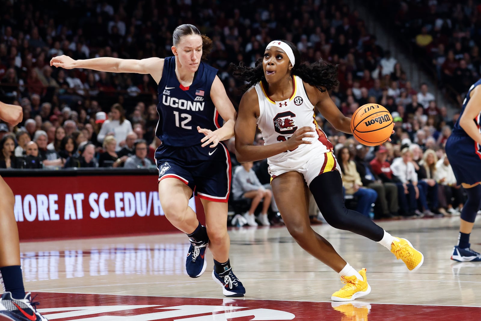 South Carolina guard Raven Johnson, right, drives against UConn guard Ashlynn Shade during the first half of an NCAA college basketball game in Columbia, S.C., Sunday, Feb. 16, 2025. (AP Photo/Nell Redmond)