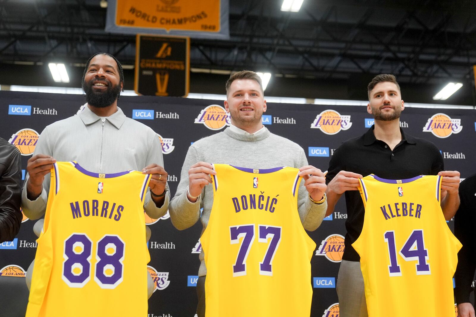 From left to right, Los Angeles Lakers' Markieff Morris, Luka Doncic and Maxi Kleber pose with their new jerseys during an introductory NBA basketball press conference Tuesday, Feb. 4, 2025, in El Segundo, Calif. (AP Photo/Jae C. Hong)