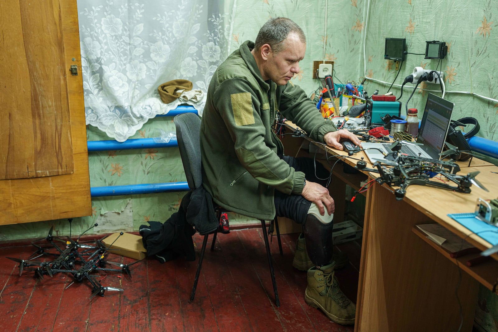 Serhii Tumanovskyi, a soldier with Ukraine's 114th territorial defense brigade, installs firmware in a drone near the front line in Ukraine's Kharkiv region on Feb. 10, 2025. (AP Photo/Evgeniy Maloletka)