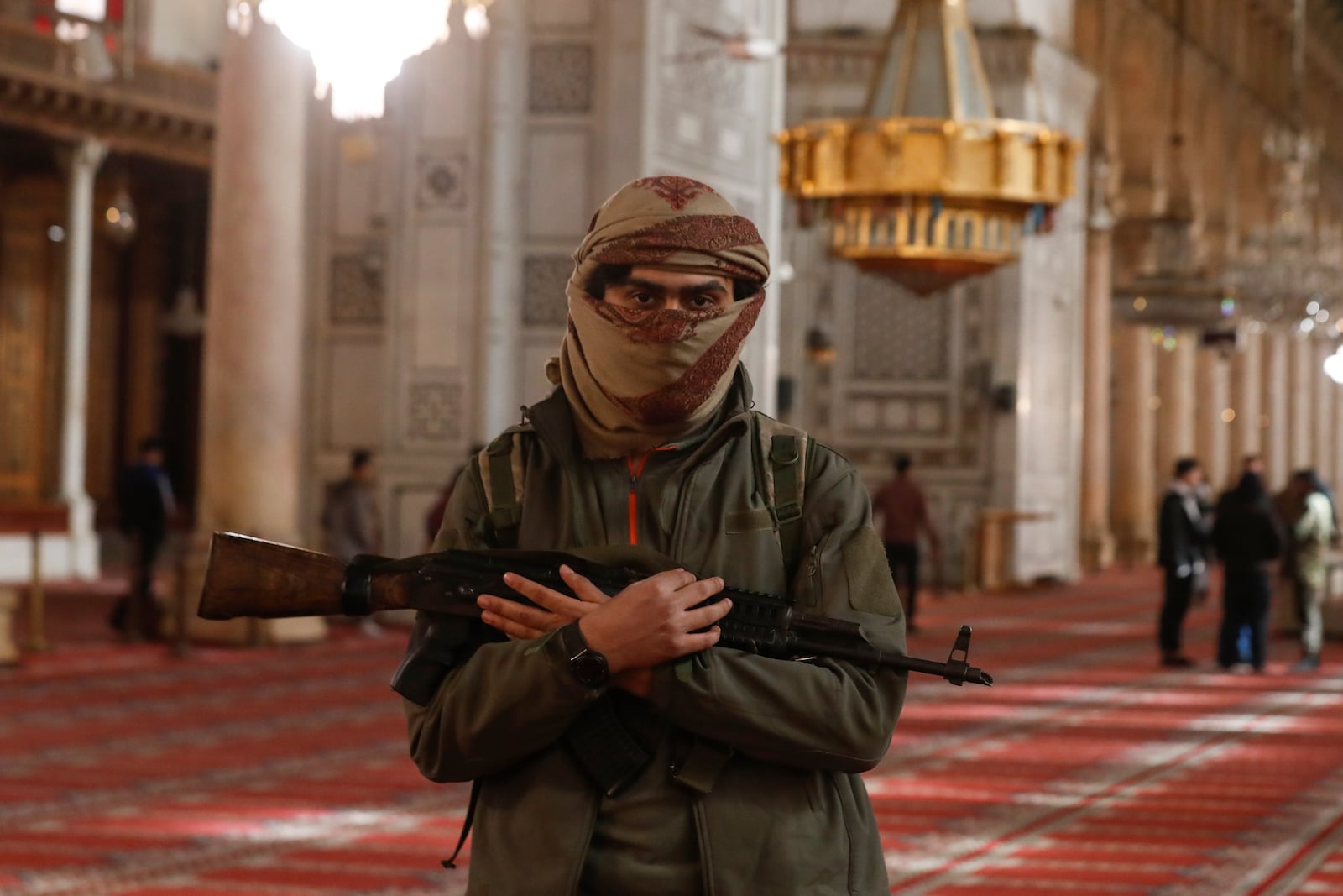 An opposition fighter poses for a photograph inside the 7th century Umayyad Mosque in Damascus, Syria, Wednesday, Dec. 11, 2024. (AP Photo/Omar Sanadiki)