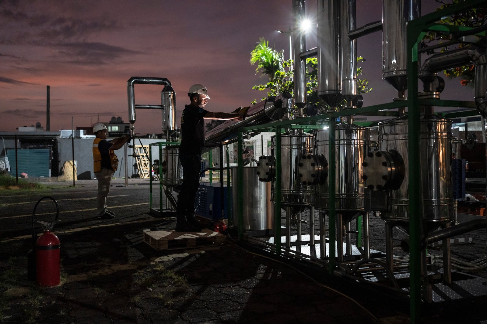 Edgar Pedroza and Carlos Parraguirre Diaz maintain and clean Petgaserita, a non-catalytic pyrolysis machine that converts plastic into fuel, after a demonstration operation in Boca del Rio, Veracruz, Mexico, Jan. 4, 2025. (AP Photo/Felix Marquez)