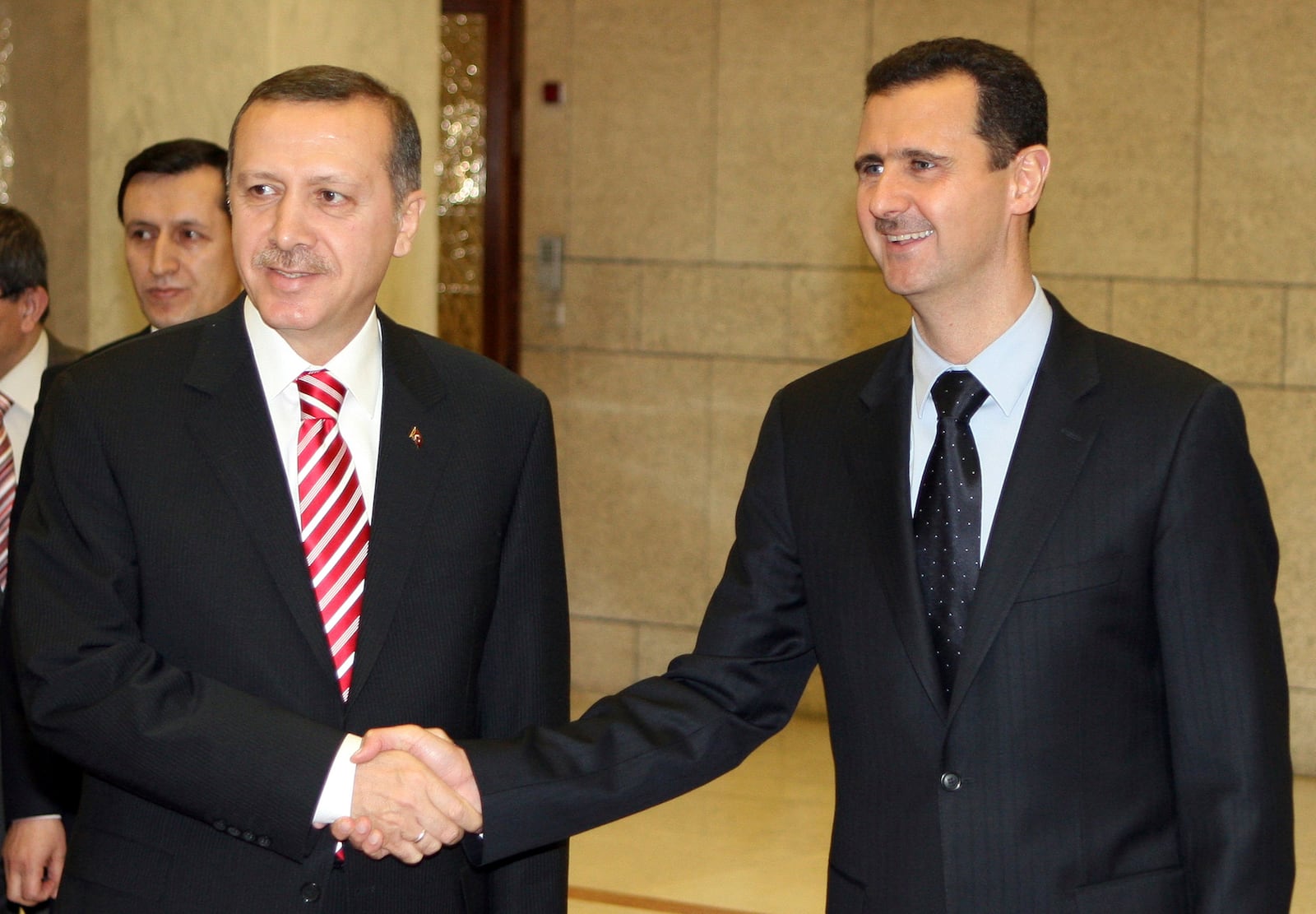 FILE - Syrian President Bashar Assad, right, shakes hands with Turkish leader Recep Tayyip Erdogan at the Ash-Shaeb presidential palace in Damascus, Syria, on April 26, 2008. (AP Photo/Bassem Tellawi, File)