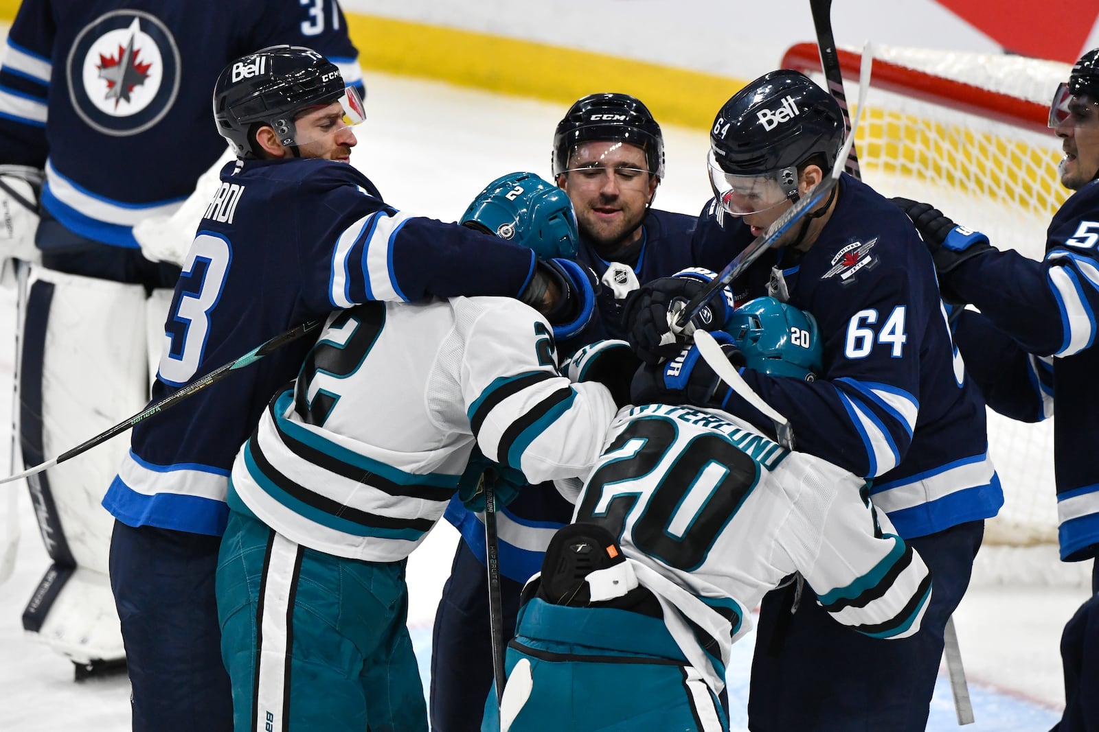 Winnipeg Jets' Gabriel Vilardi, Neal Pionk and Logan Stanley (64) tangle with San Jose Sharks' Will Smith (2) and Fabian Zetterlund (20) during the first period of an NHL hockey game in Winnipeg, Manitoba, Monday, Feb. 24, 2025. (Fred Greenslade/The Canadian Press via AP)