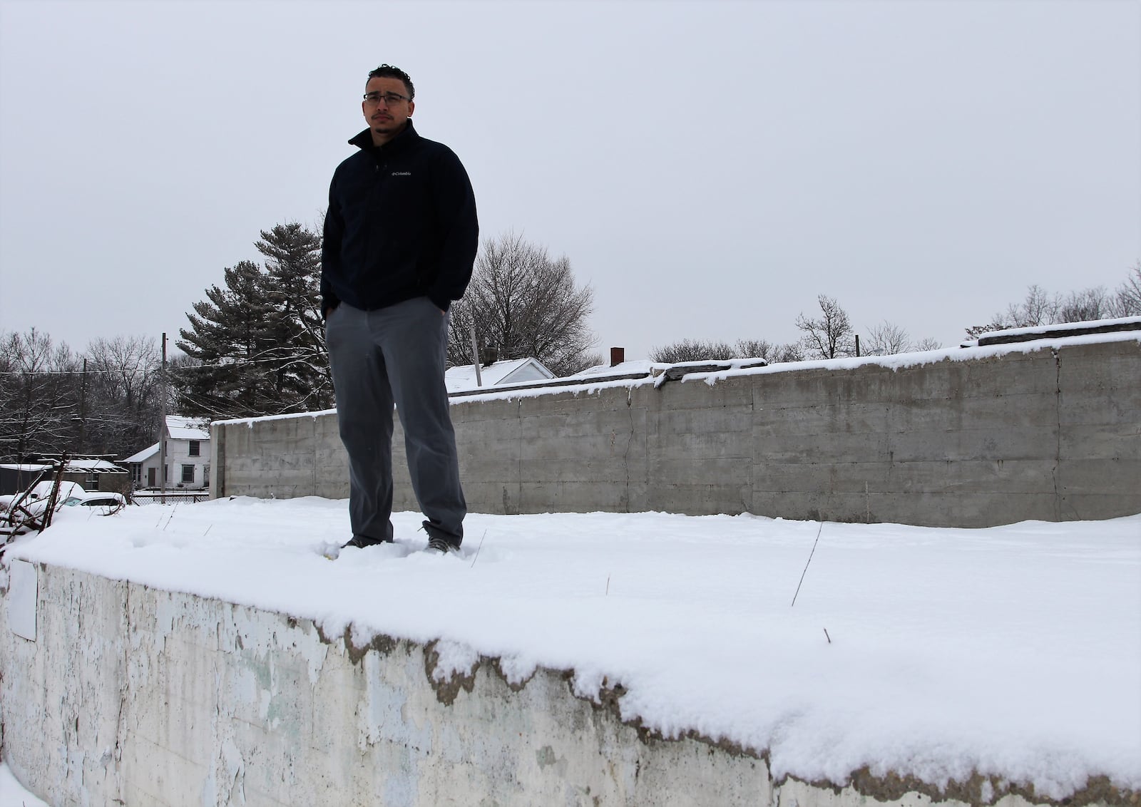 Alex Robinson stands on the foundation of what used to be a manufacturing facility located on a little over 3 acres of property on South Yellow Springs Street. Robinson purchased the land this year and hopes to build a two-story sports complex on it. Hasan Karim/ Staff