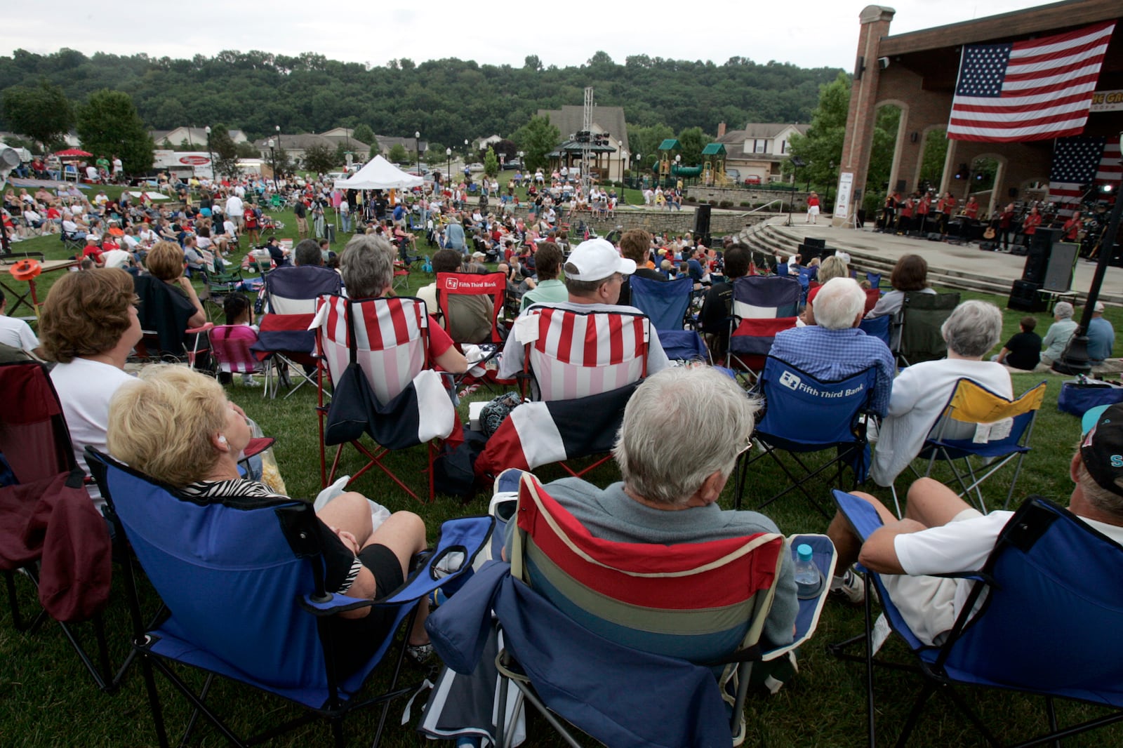 Spectators listen to the band performances on stage during previous Red, White and Kaboom Independence Day celebration at Village Green in Fairfield. FILE PHOTO