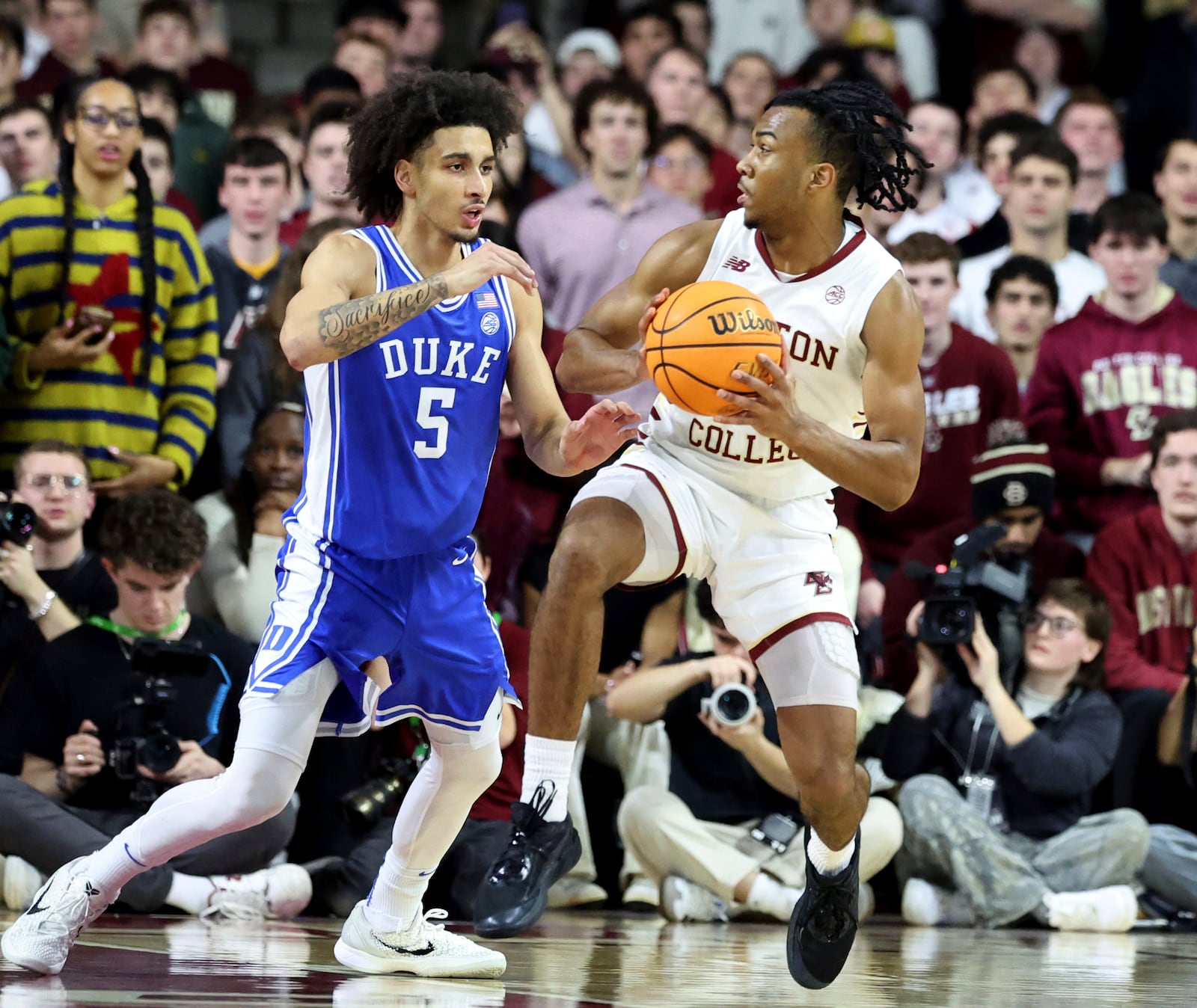 Boston College guard Donald Hand Jr. (13) defends the ball from Duke guard Tyrese Proctor (5) during the first half of an NCAA college basketball game Saturday, Jan. 18, 2025, in Boston. (AP Photo/Mark Stockwell)