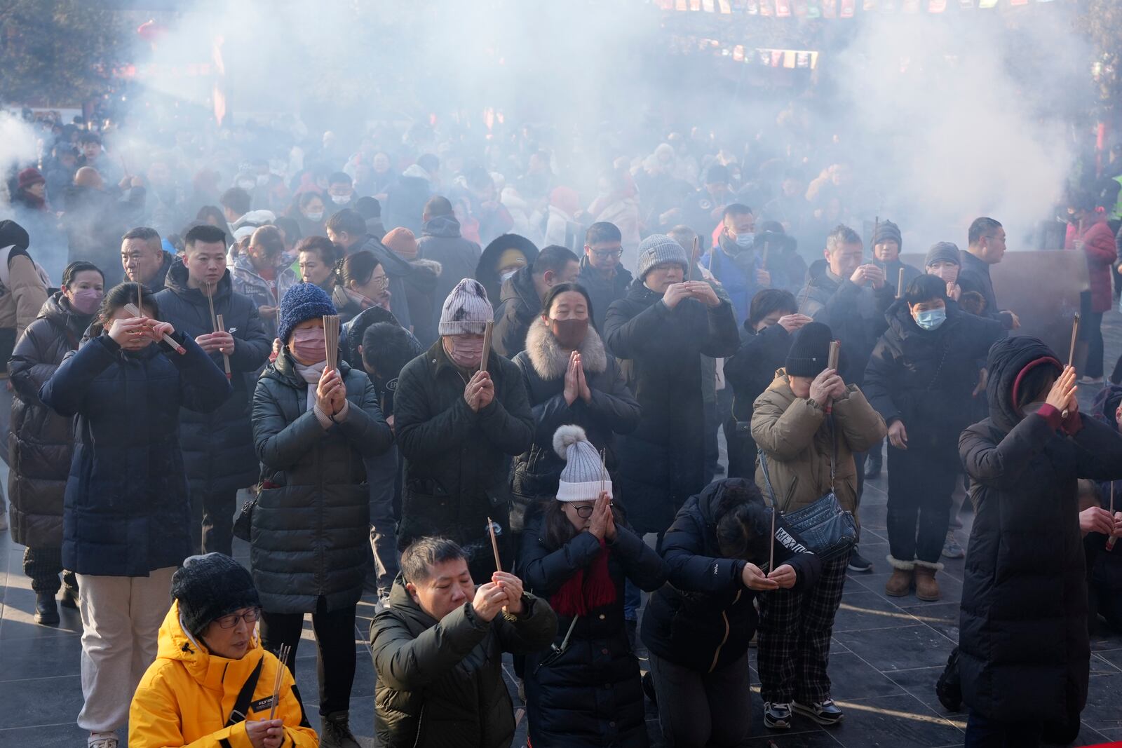 People holding incense sticks pray on the first day of the Chinese Lunar New Year at Lama Temple in Beijing on Wednesday, Jan. 29, 2025. (AP Photo/Aaron Favila)