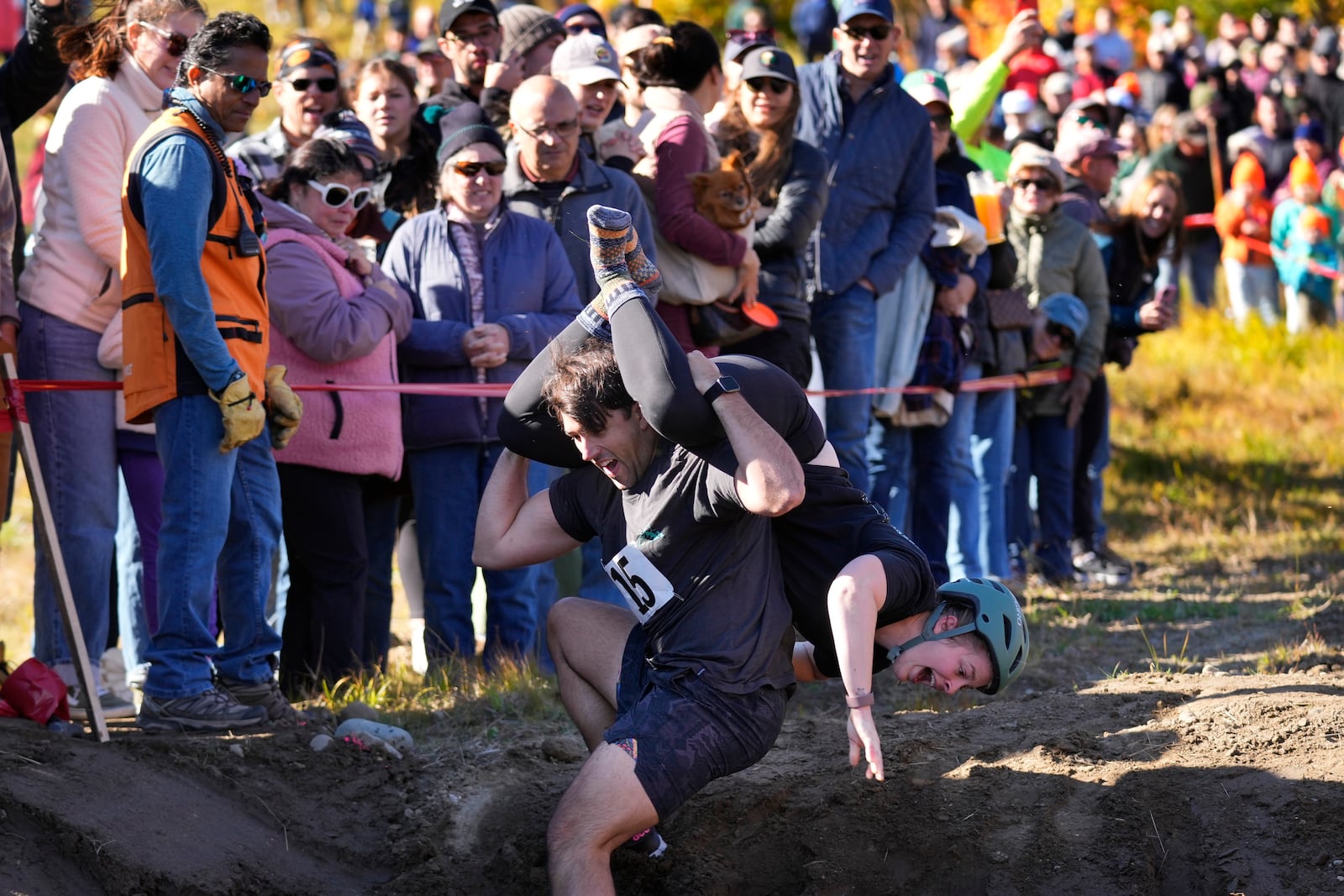 Nic Vinsonhaler looses his footing while carrying Tara Rogowski during the North American Wife Carrying Championship, Saturday, Oct. 12, 2024, at Sunday River ski resort in Newry, Maine. (AP Photo/Robert F. Bukaty)