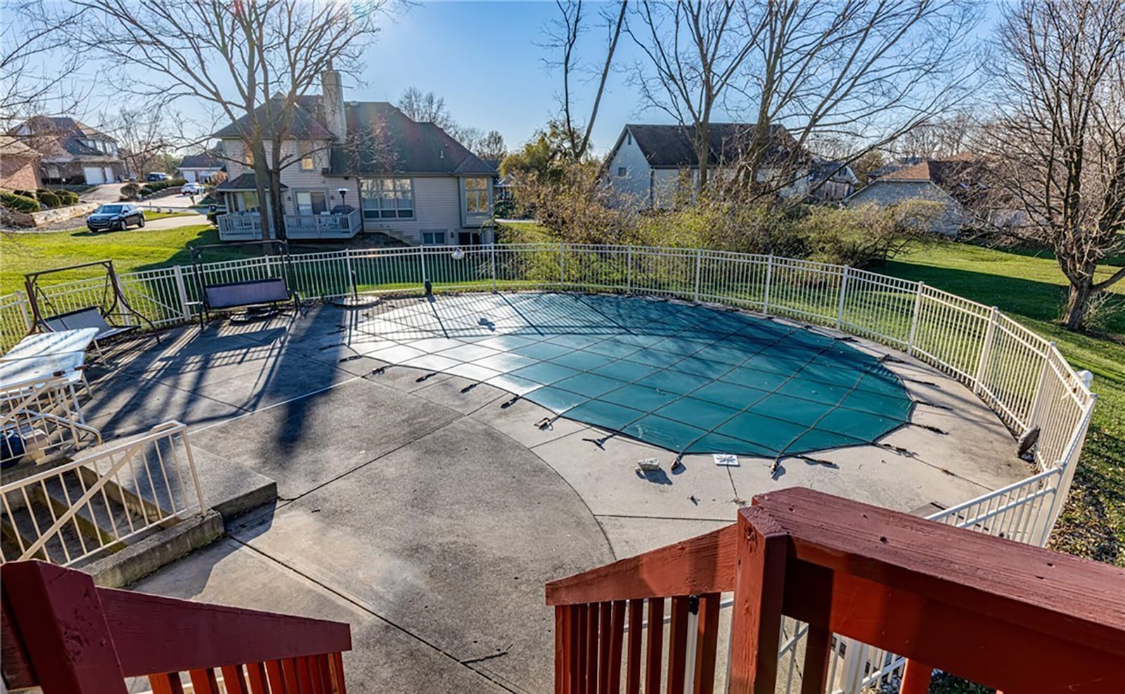 The home has an inground pool surrounded by a fence and concrete patio.