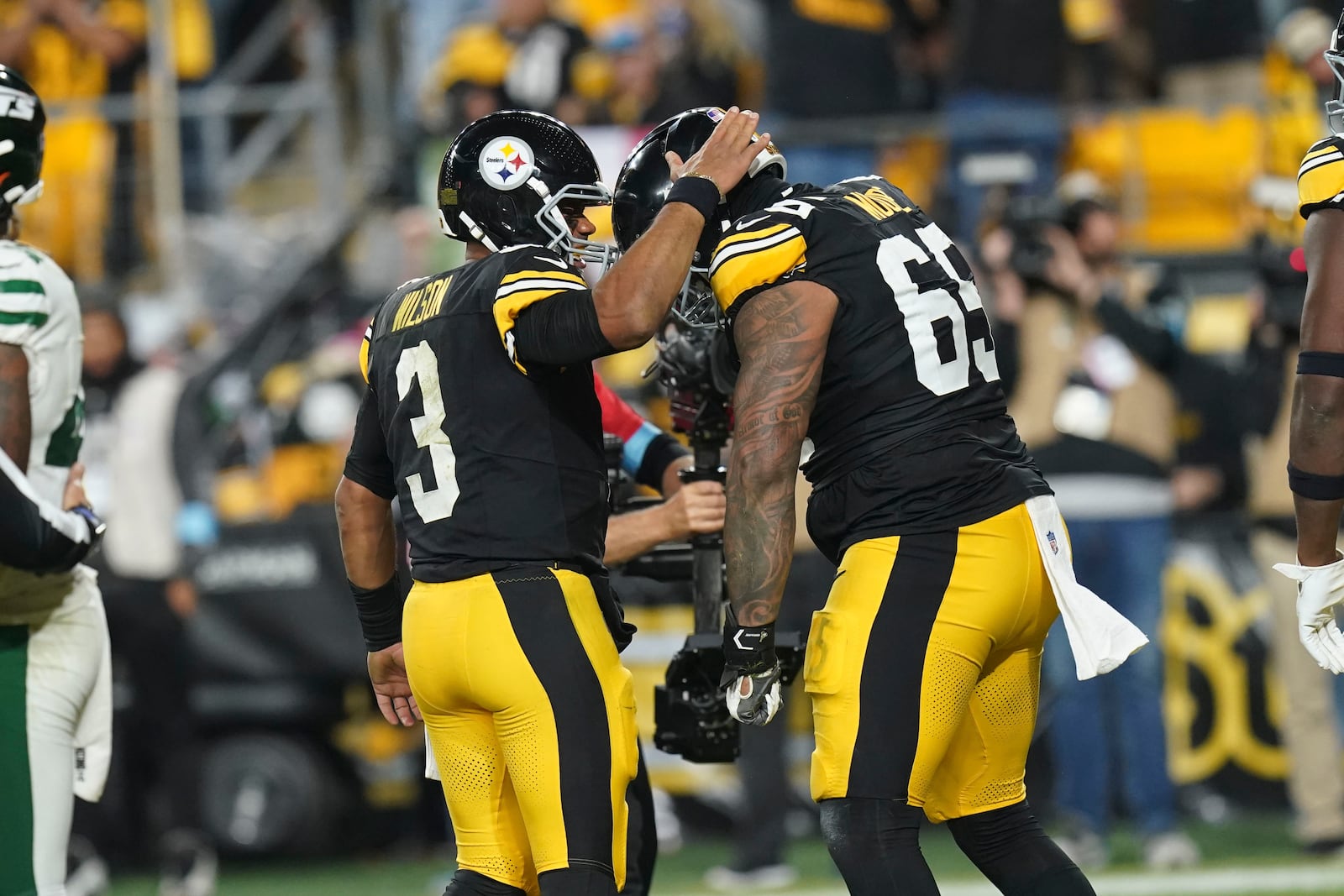 Pittsburgh Steelers quarterback Russell Wilson (3) celebrates his touchdown with offensive tackle Dan Moore Jr. (65) in the second half of an NFL football game against the New York Jets in Pittsburgh, Sunday, Oct. 20, 2024. (AP Photo/Matt Freed)