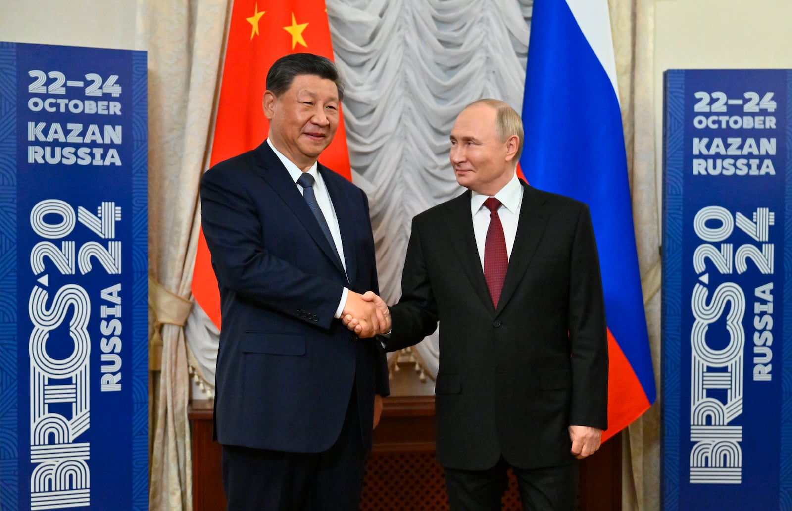 Russian President Vladimir Putin, right, and Chinese President Xi Jinping shake hands during their meeting on the sidelines of BRICS Summit at Kazan Kremlin in Kazan, Russia, Tuesday, Oct. 22, 2024. (Kristina Kormilitsyna/Photo host brics-russia2024.ru via AP)